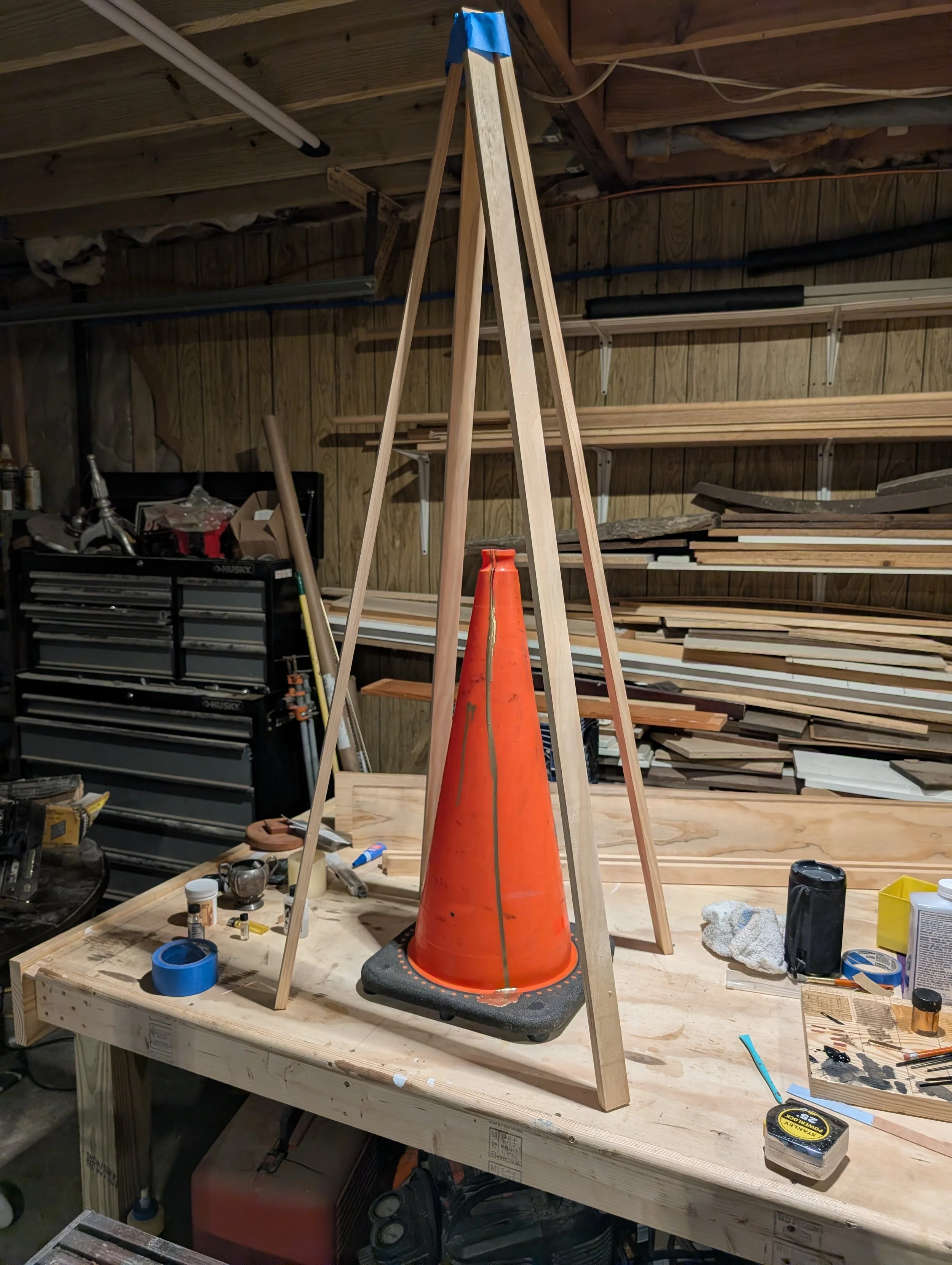 Pyramidal Jig & Gilded Cone

Studio setup using a custom wood framing jig to apply gold leaf and perspective lines to a traffic cone.