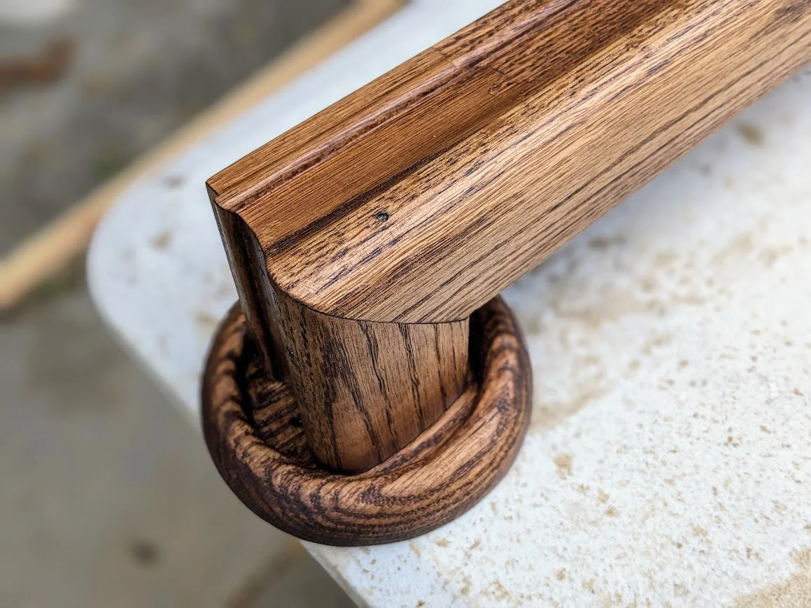 Hand-Carved Oak Handrail Termination | Custom-shaped return miter joined to a hand-shaped circular rosette collar with deep grain stain detail