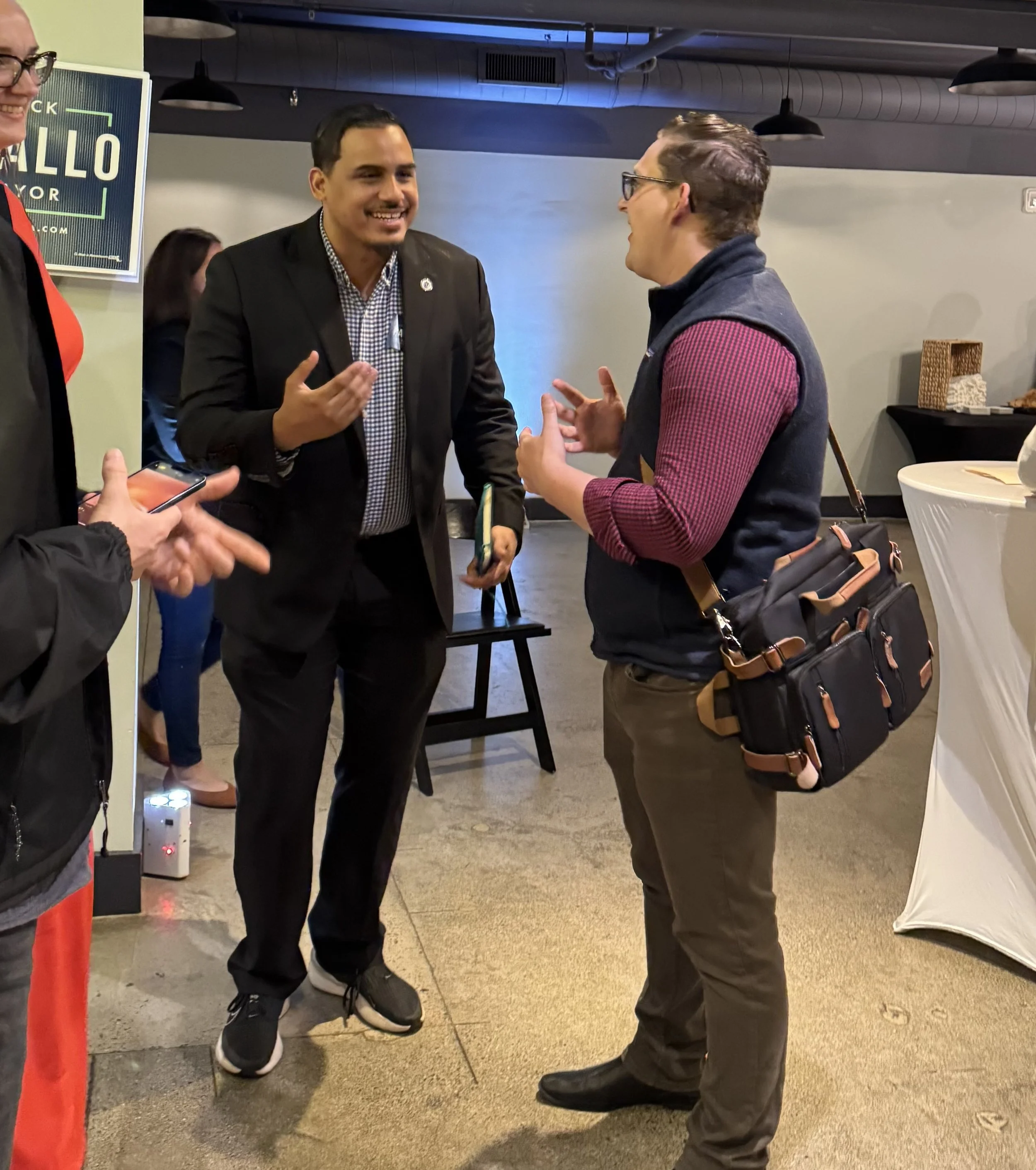 John and Rep. Manny Cruz engrossed in conversation at a campaign event for Mayor Dominick Pangallo