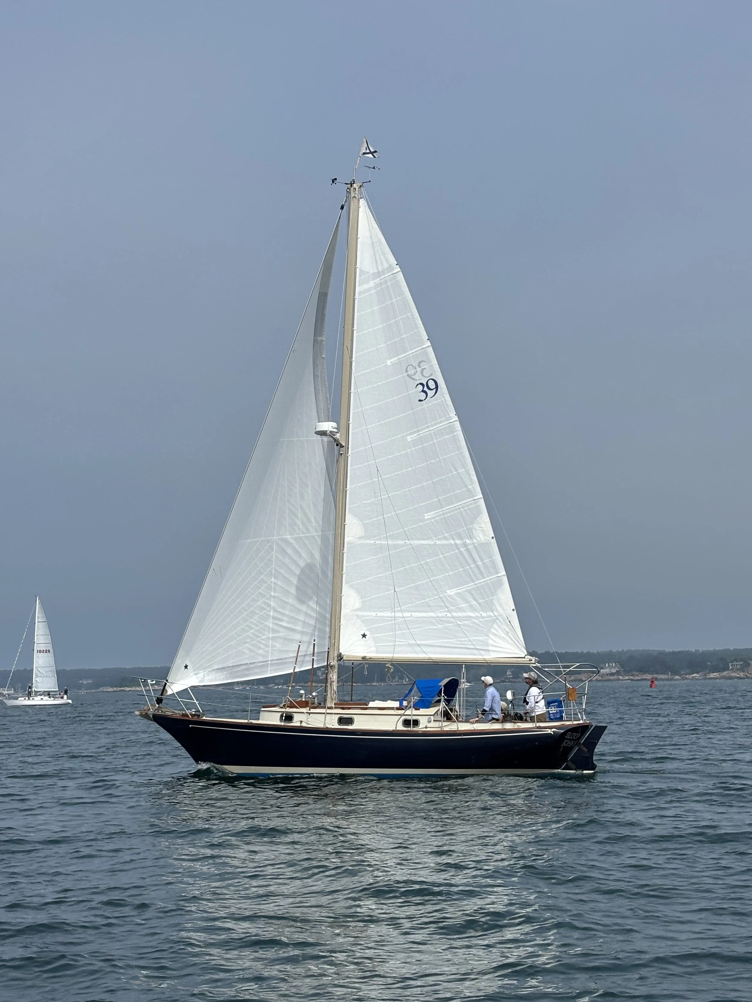 Sloop John B, a blue-hulled sailboat with Jib and Mainsail unfurled.