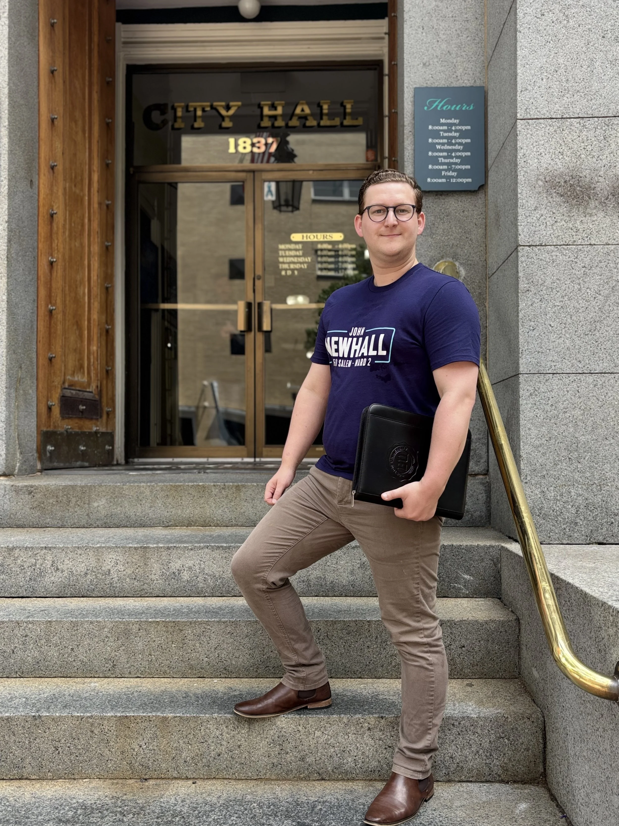 John in a campaign t-shirt on the steps of City Hall.