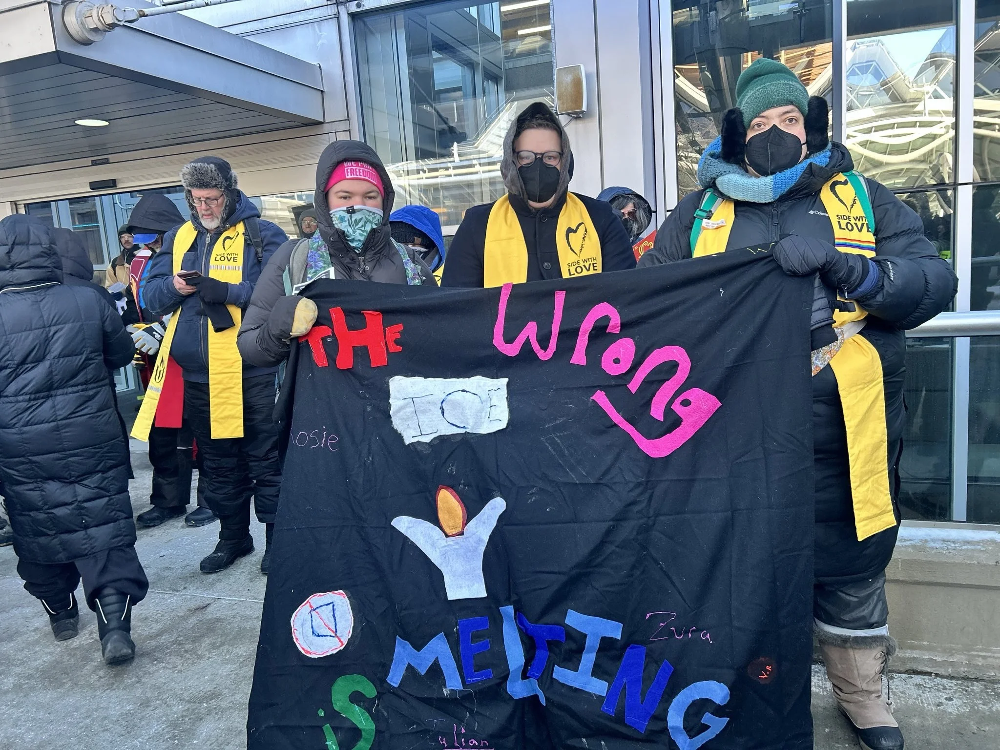 John (center) with two other Unitarian Universalists at the Minneapolis Airport protesting ICE occupation.