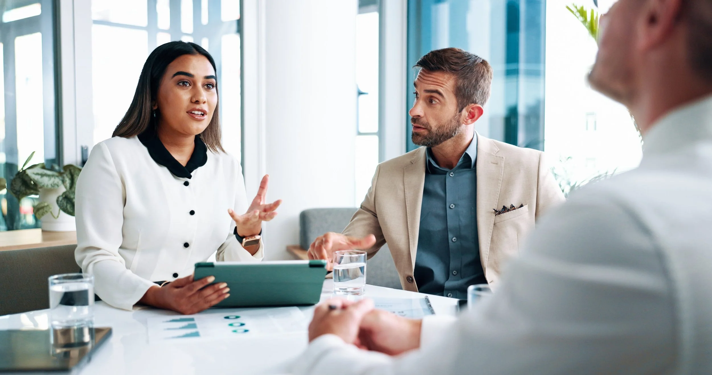 Three professionals discuss CPA liability insurance options during a client meeting