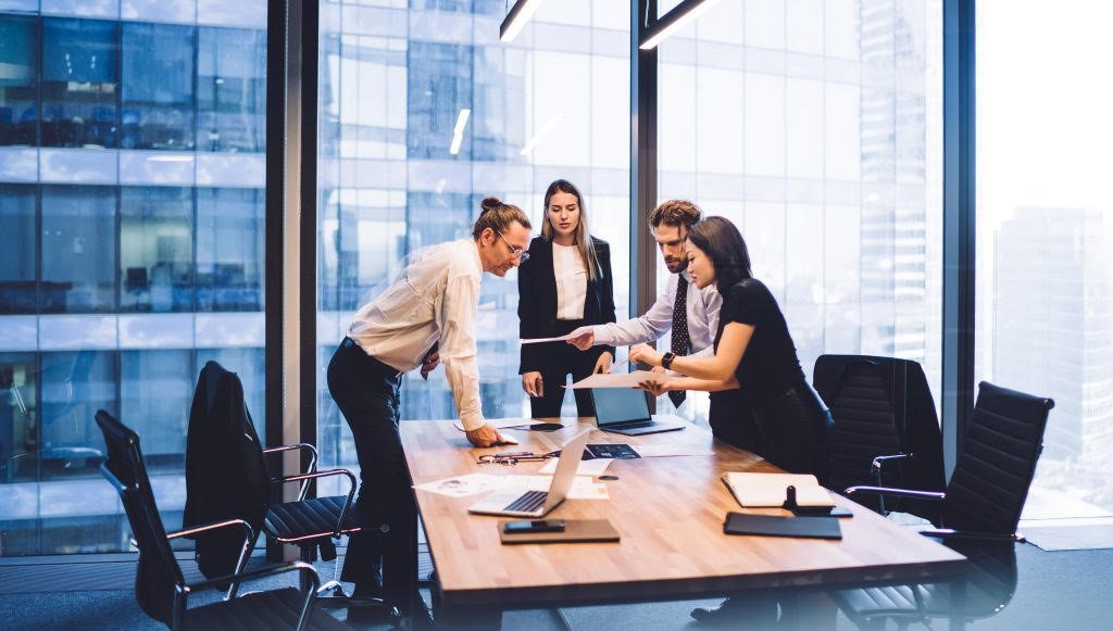 Accounting firm team reviews documents together in a modern conference room
