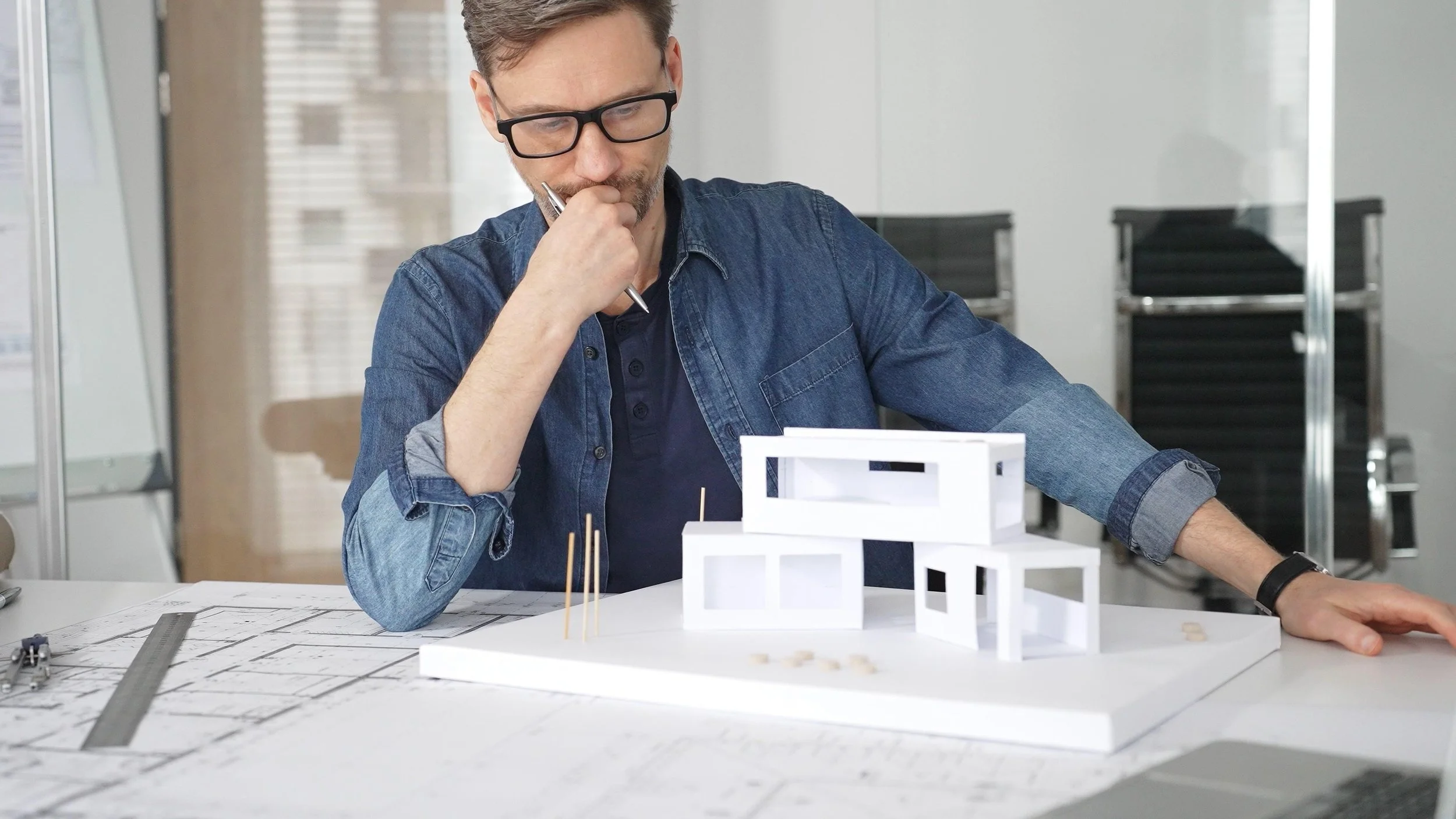 Man fixing architectural mock-up through post-project learning