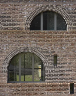 Rectangular brick building with arched windows on several levels