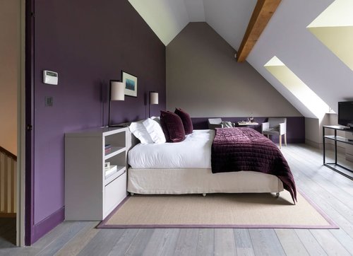 Bedroom with a deep purple wall and a slanted wall