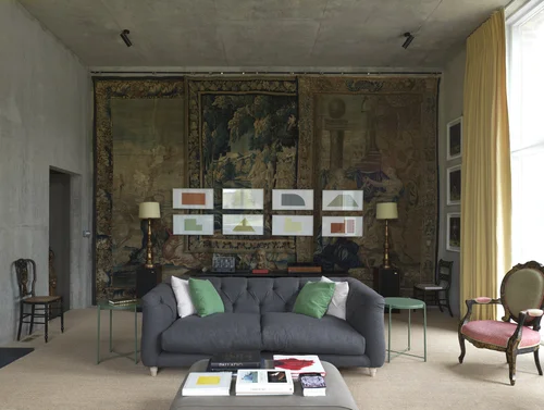 Living area with green couch and antique faded wallpaper