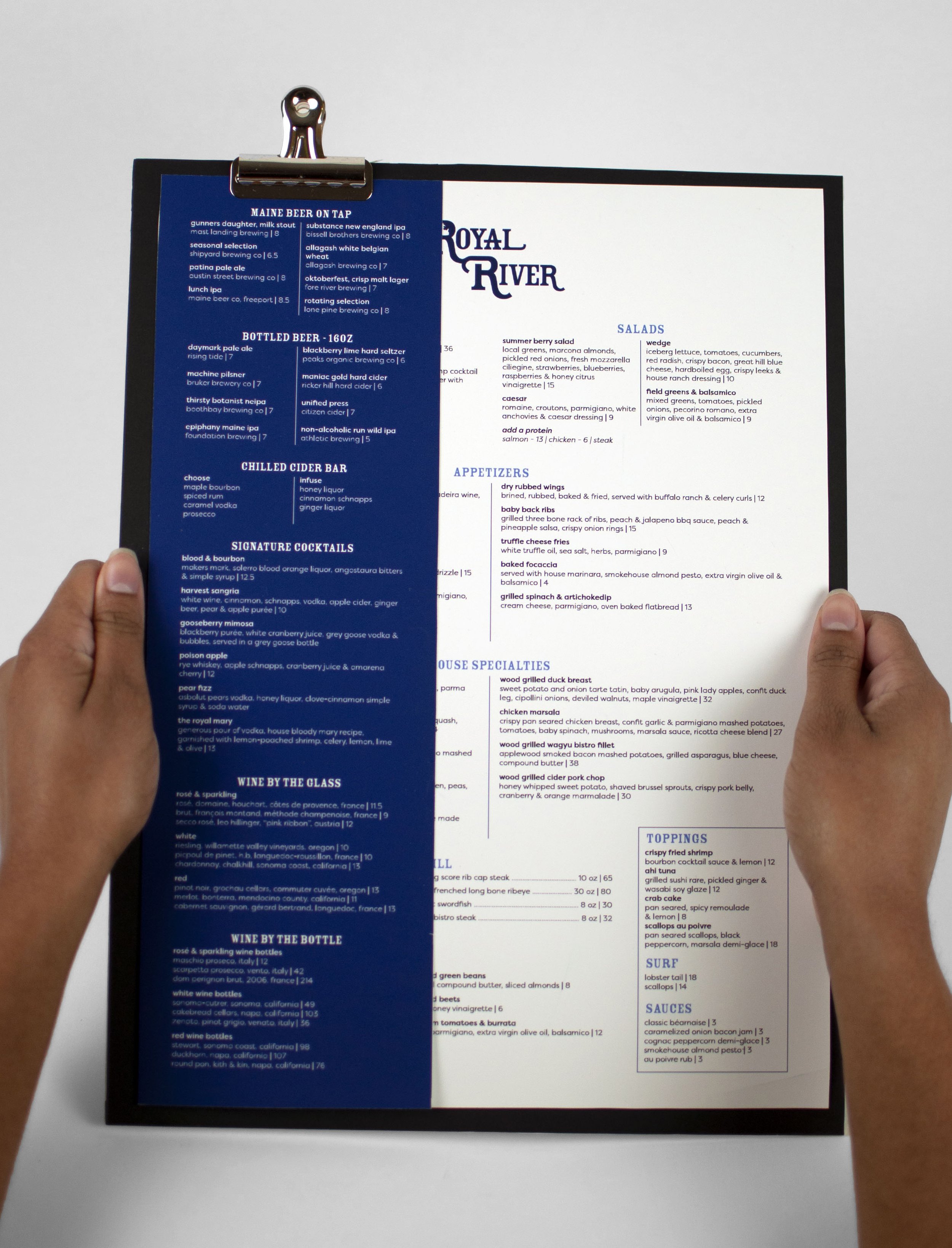 two hands holding the royal river menu board