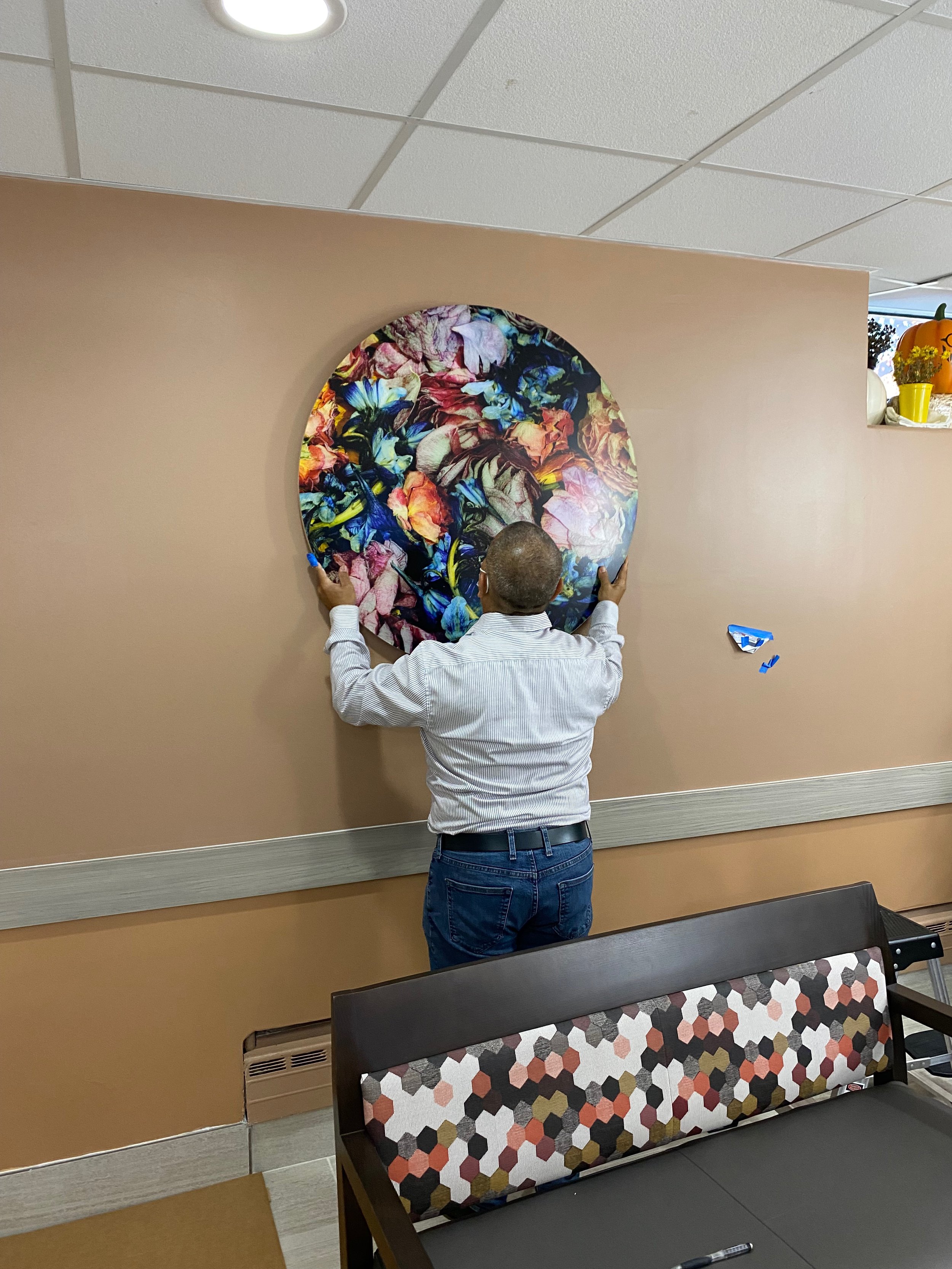 Professional art installer Anthony Pirro III installing Dora Somosi's Floral Tondo #7