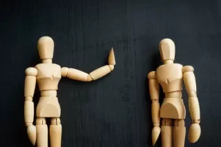 Image of wooden dolls being assertive