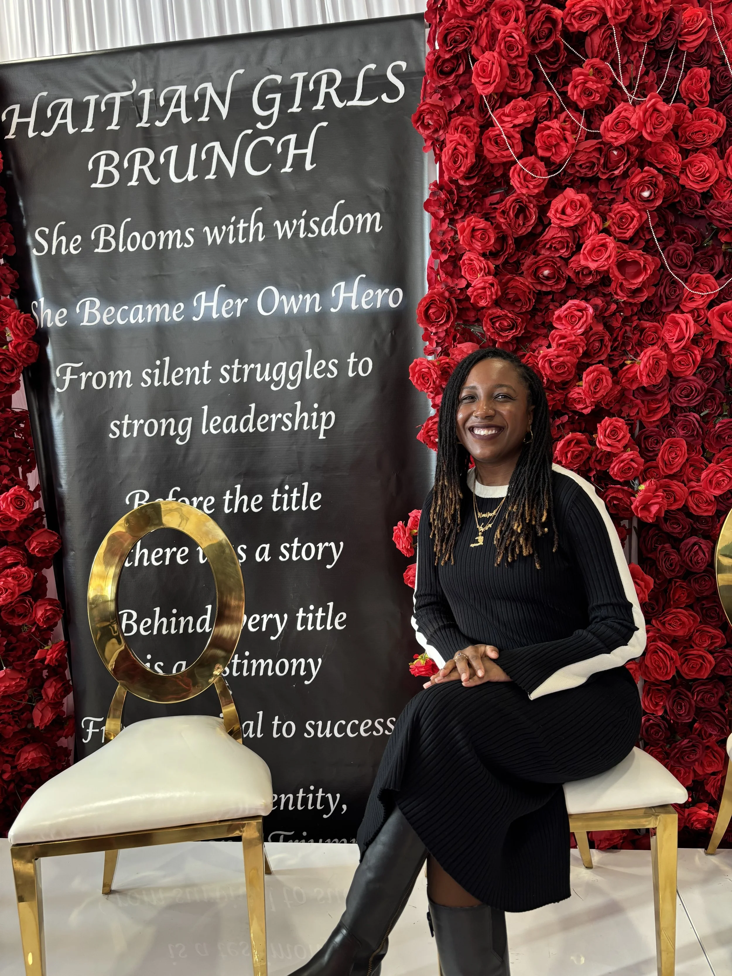 The Haitian Girls Brunch shot — Jessica Thomas, LMHC, LPC seated against the red rose wall.