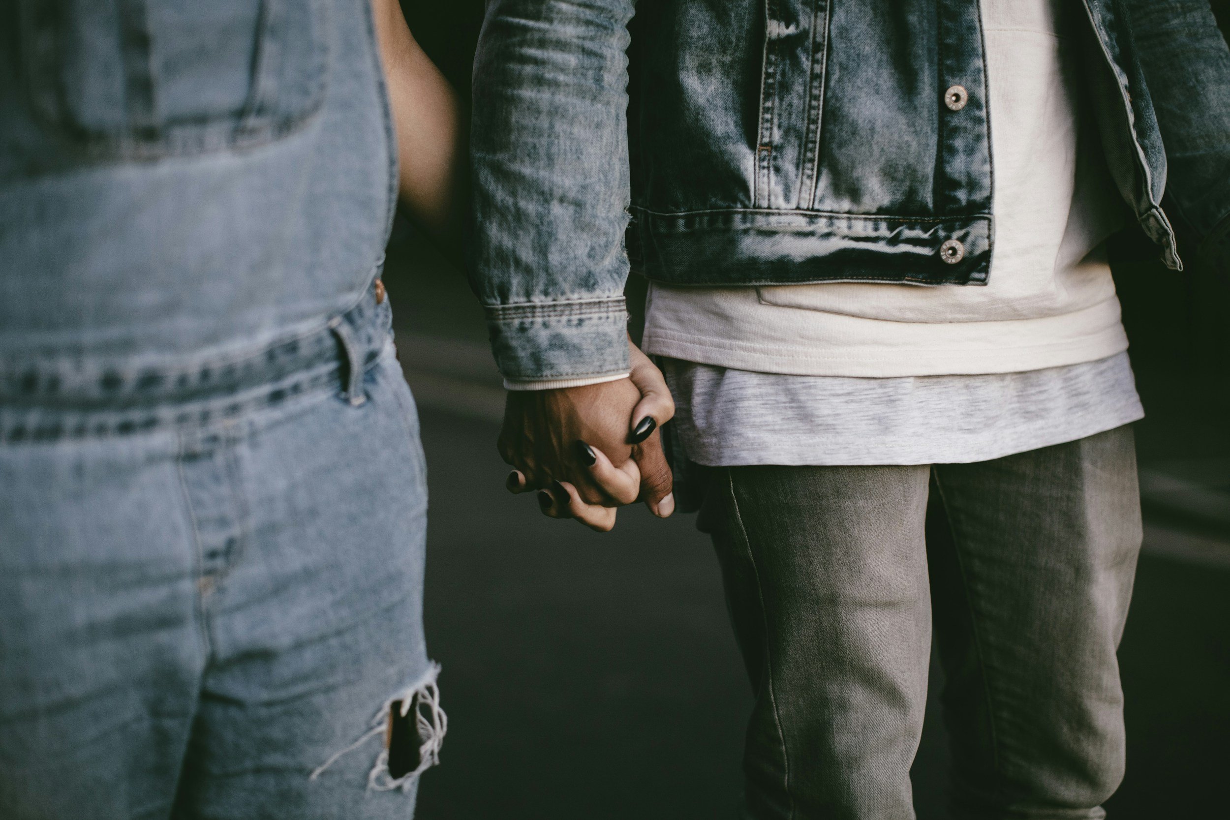 On MyMindset NYC Counseling Services website a close-up of a couple holding hands, wearing denim jackets and jeans.