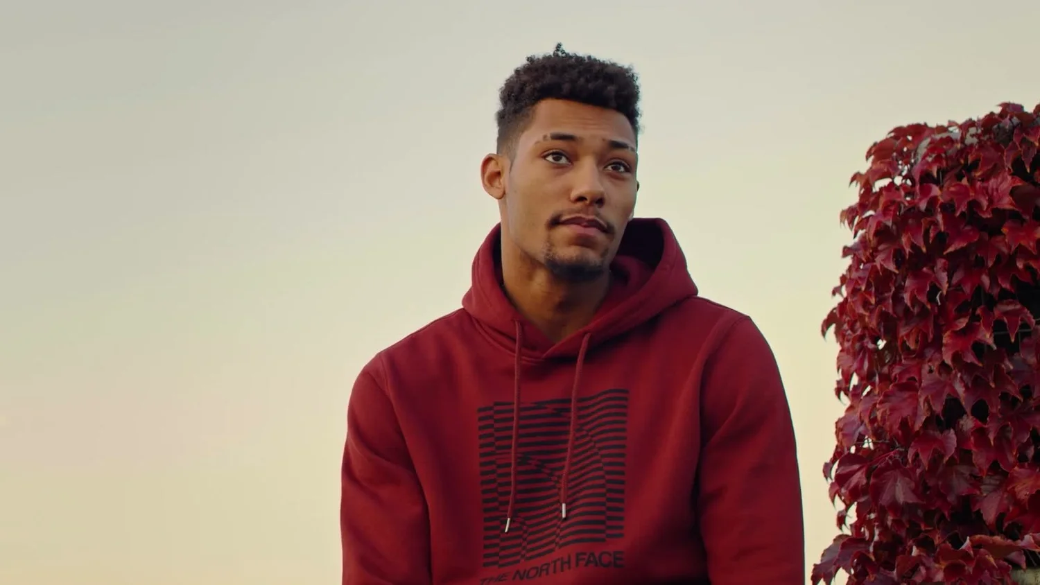 K’Andre Miller in a red hoodie on a rooftop, from The Playbook.