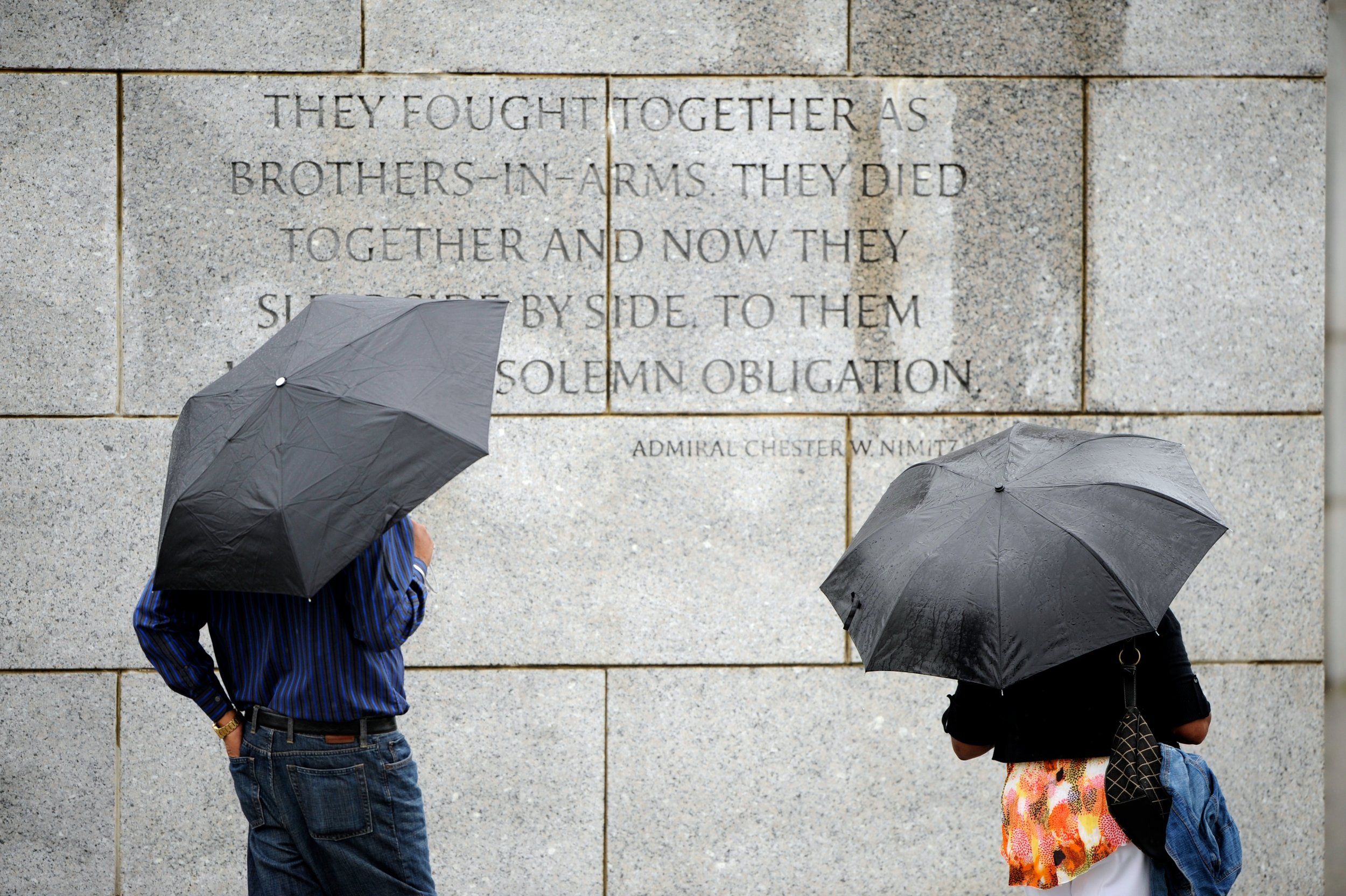Tourists read an inscription on the WW II Memorial Wall.