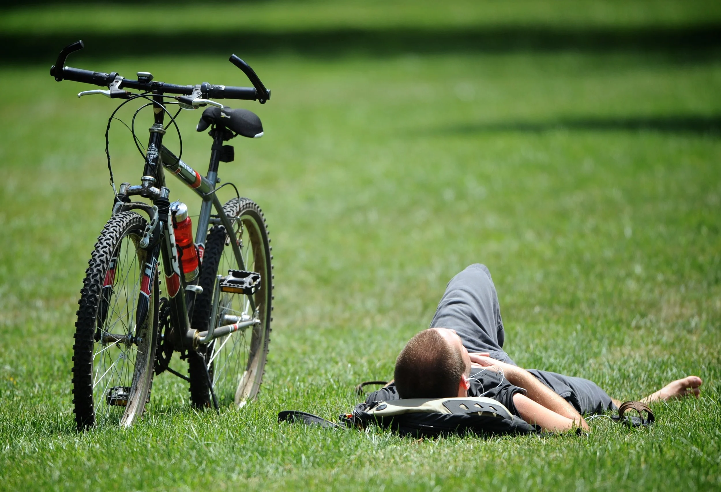 A cyclist enjoys a break on the National Mall's grass.