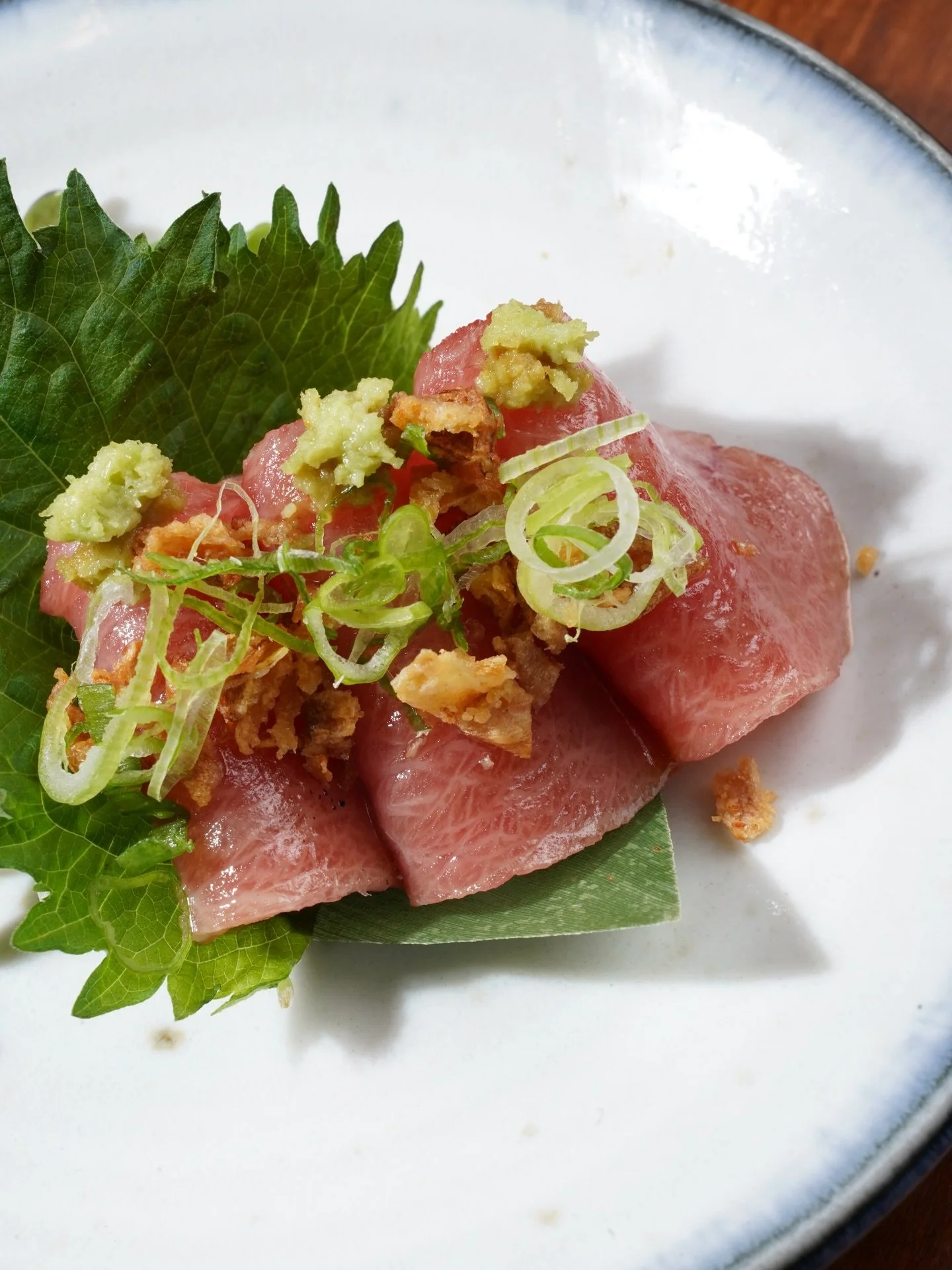 Chutoro sashimi with scallions, served on a fresh Shiso leaf. A recent Omakase appetizer crafted by the chef at our Brooklyn location