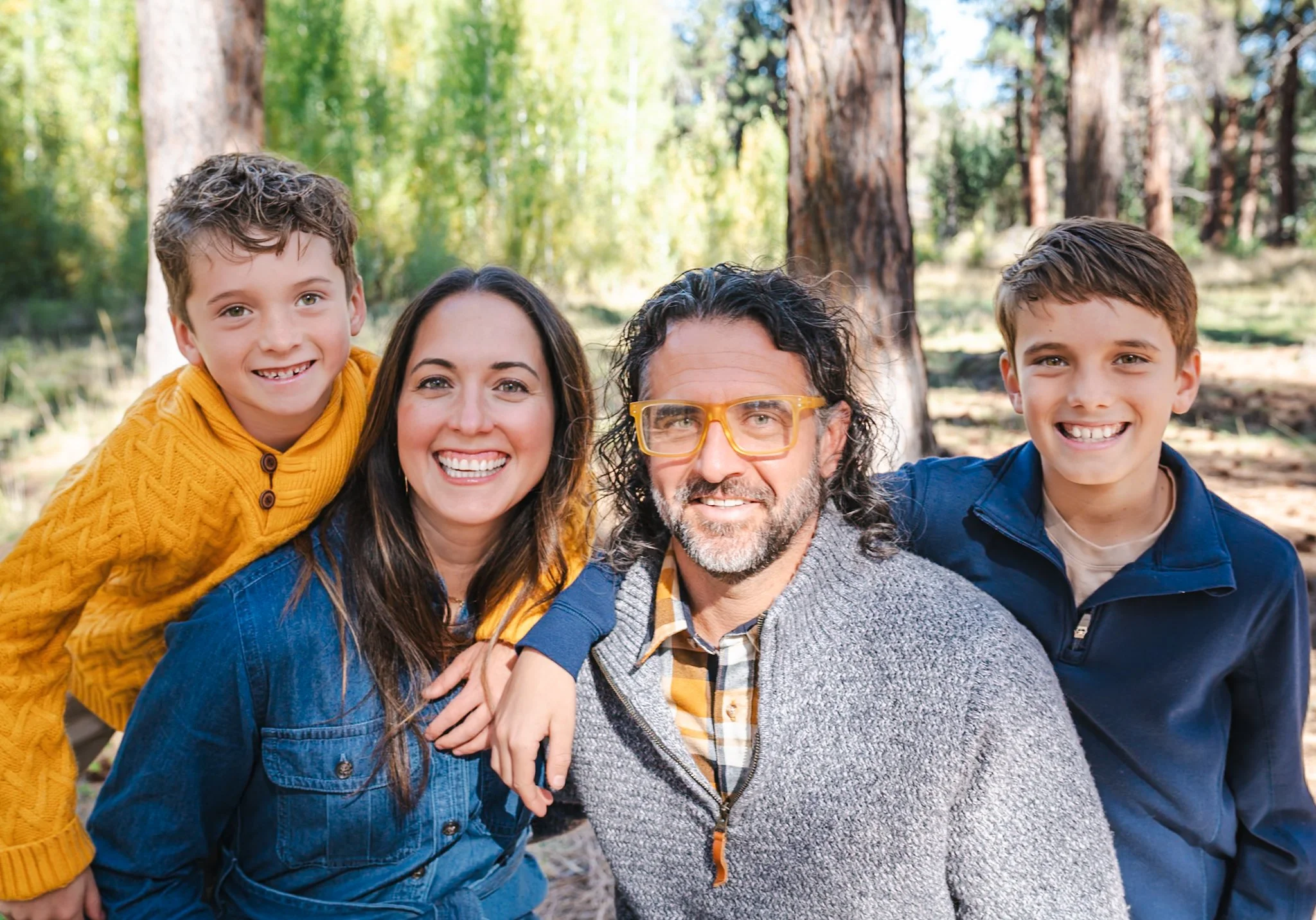 Happy family of four outdoors in at Shevlin Park, smiling for a group photo.