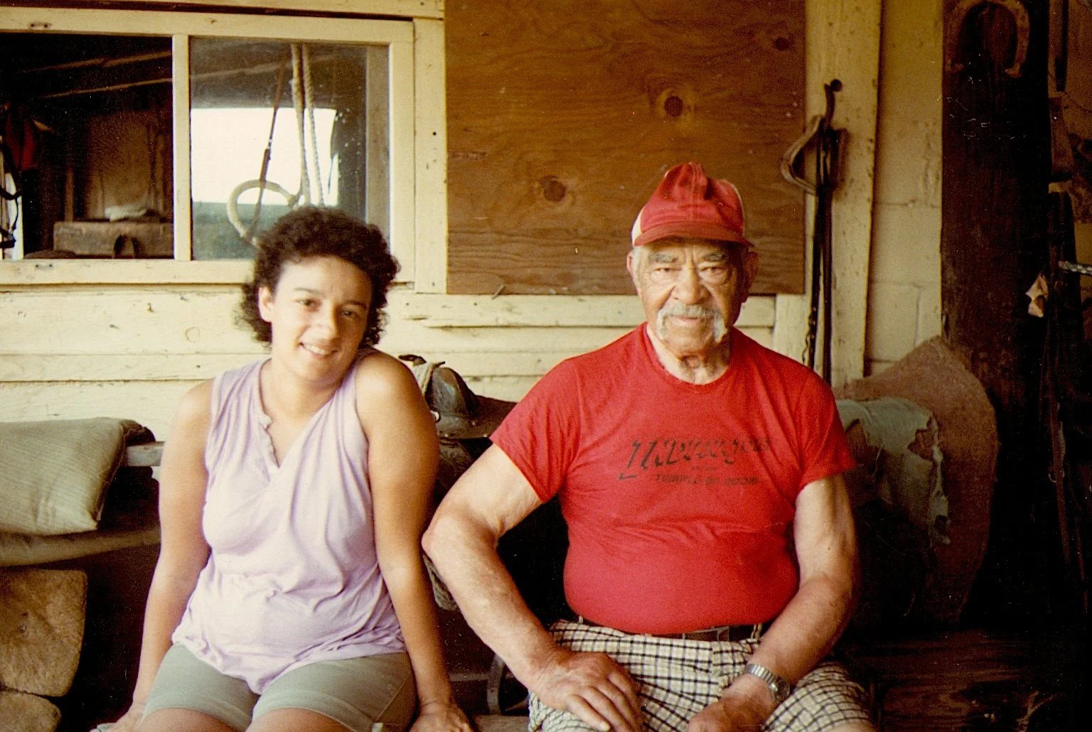 Image of the author sitting with her father at the farm