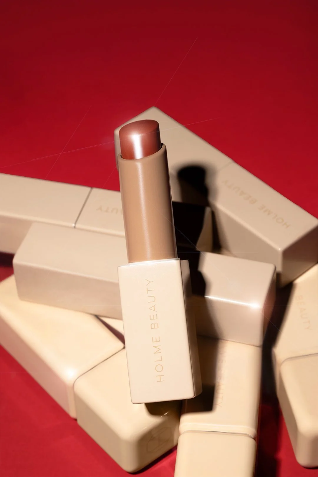 Photo of brown lip stick, stacked on 6 other closed lip sticks.