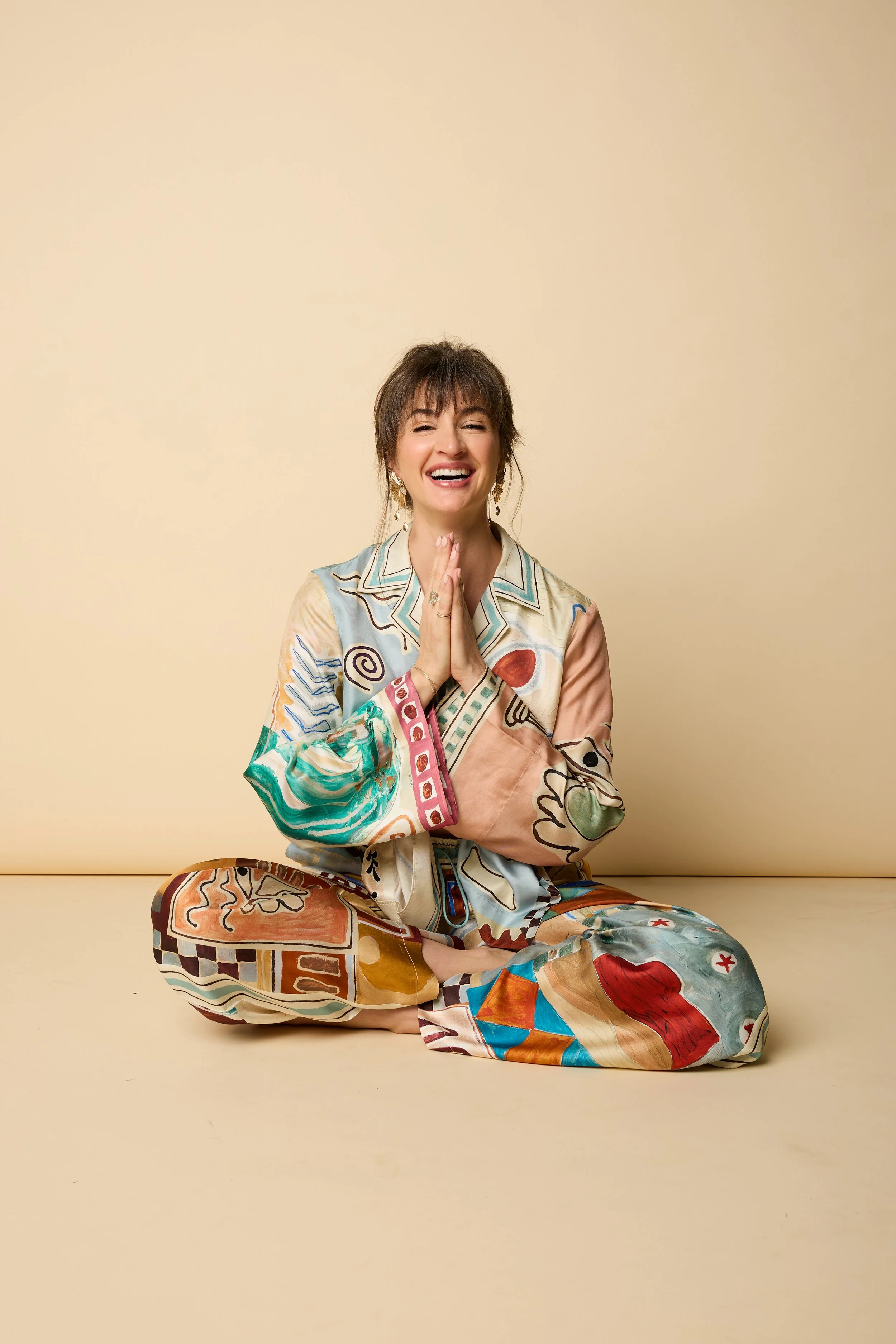 Lillian in colorful silk, seated with hands together