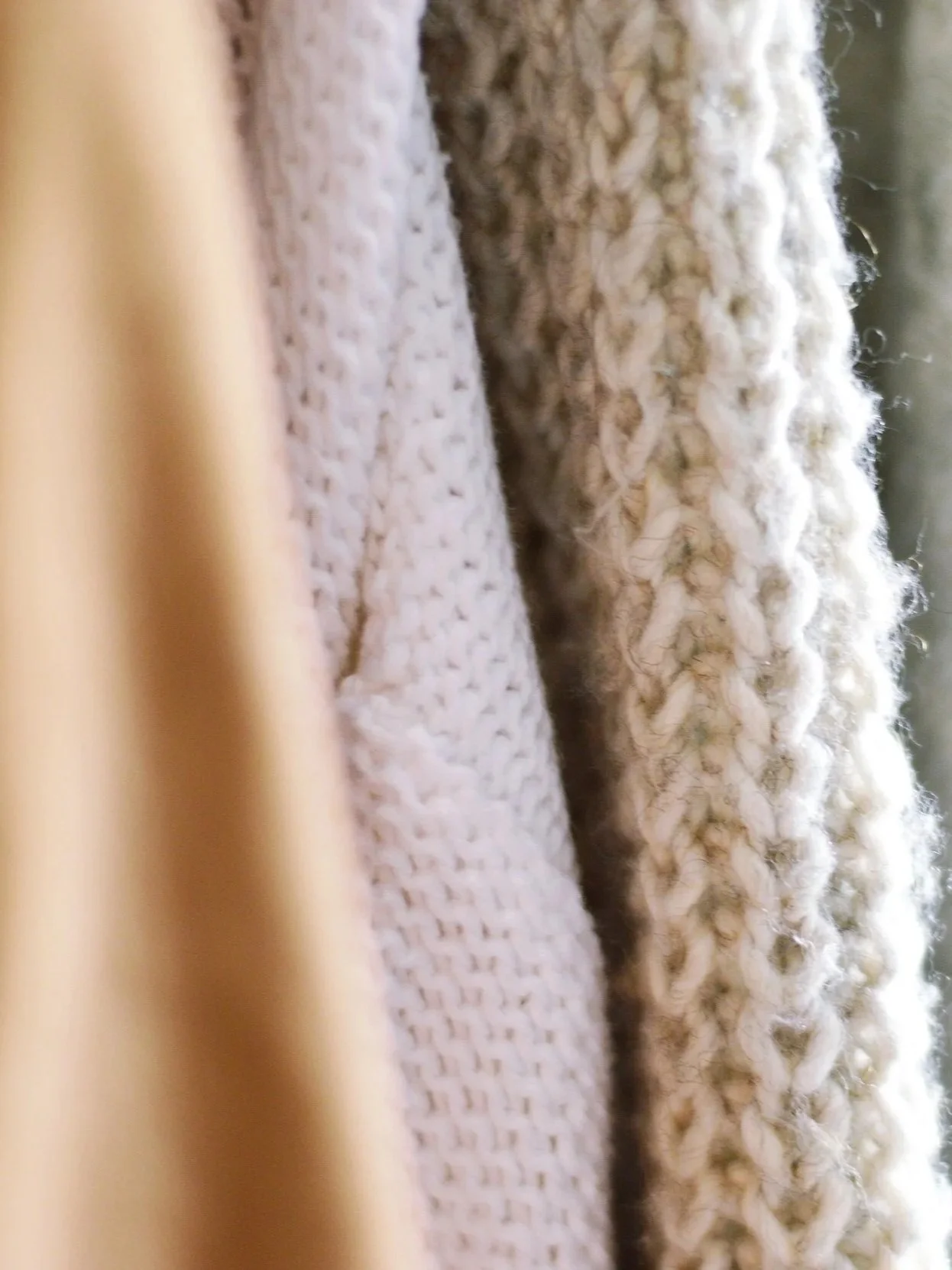 Close-up of multiple layers of textured and knitted fabric in shades of beige and cream.
