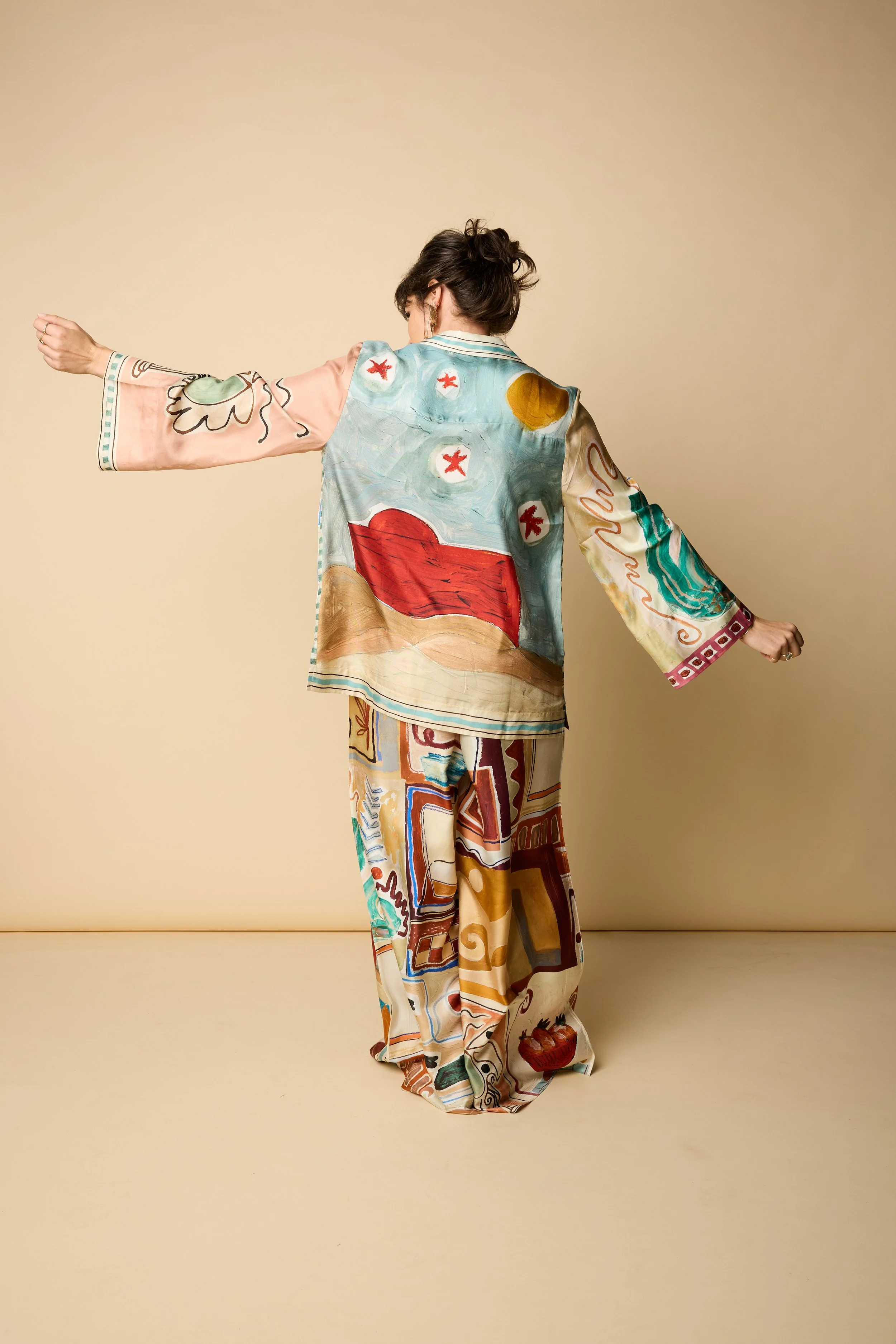 Lillian in colorful silk, standing with arm extended