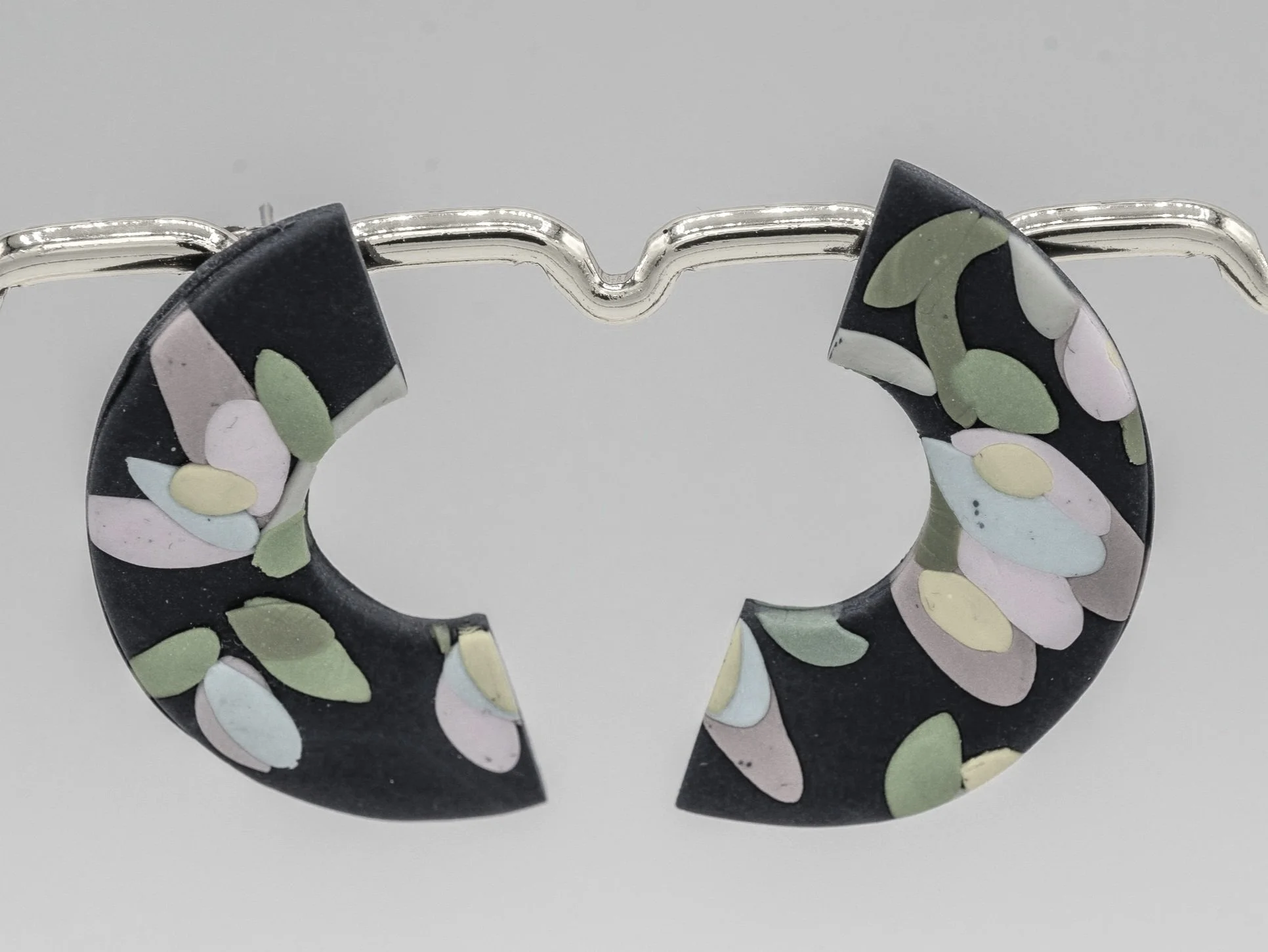 Dunkelblaue Ohrstecker aus Polymerton mit Blumenmuster.