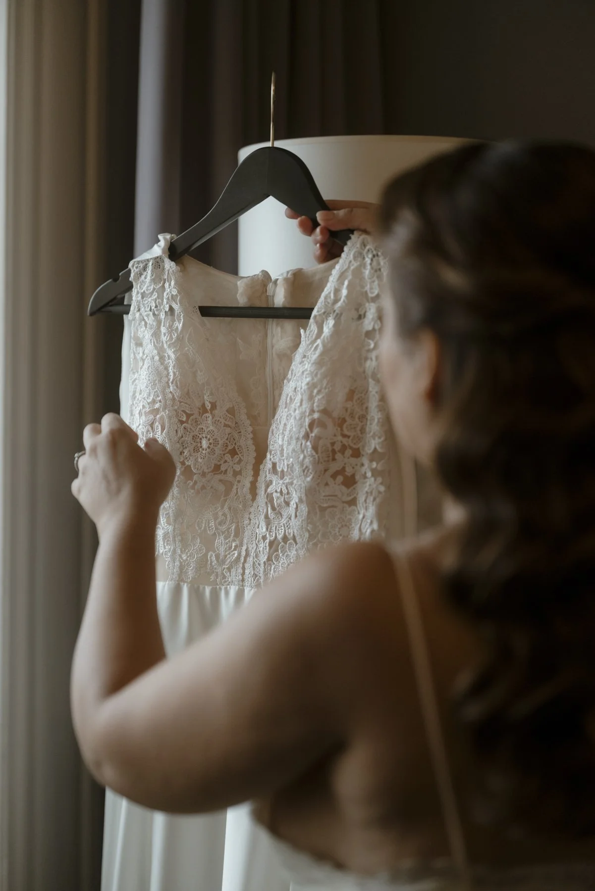 bride taking the wedding dress from the hanger