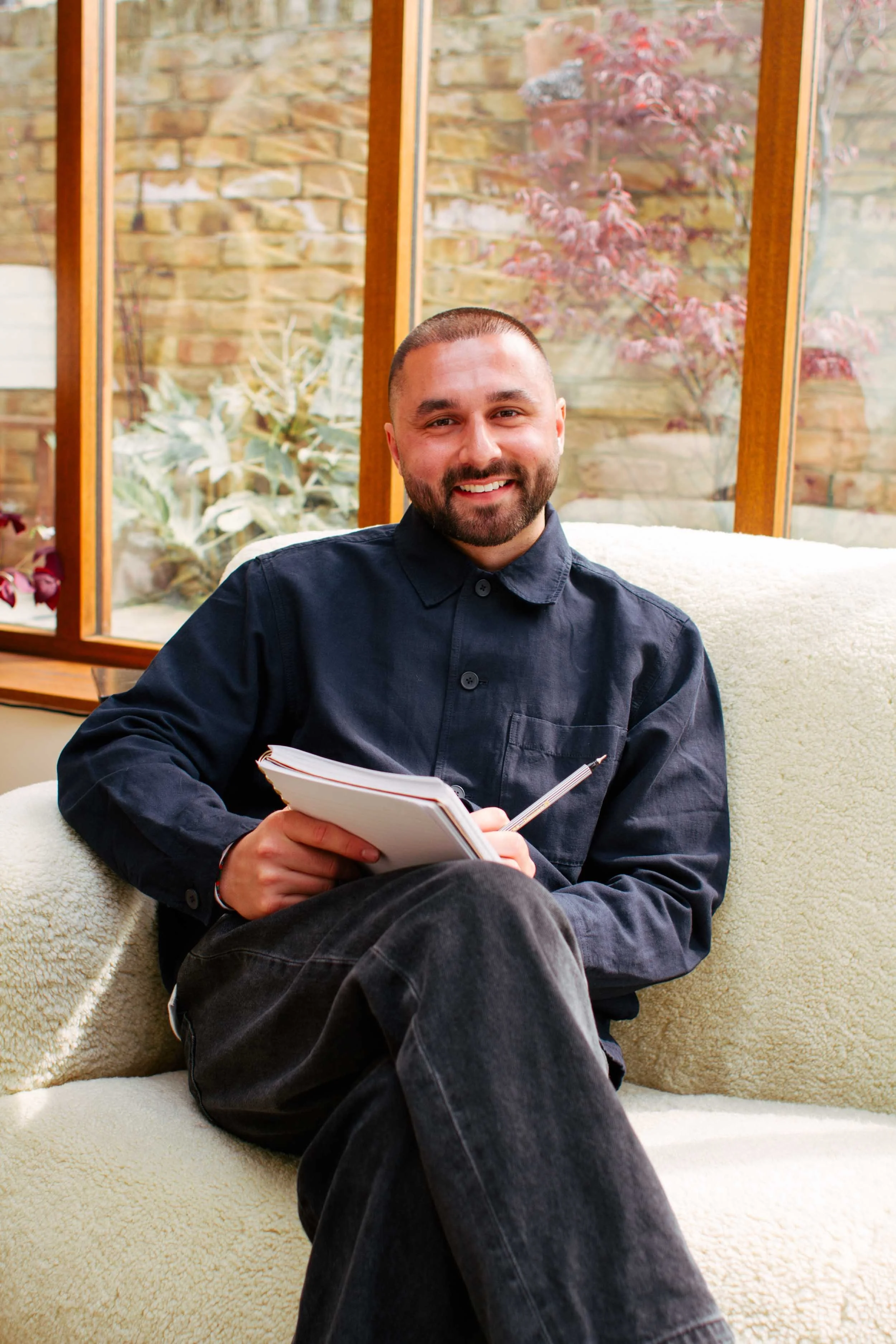 Integrative hypnotherapist sitting in a light-filled therapy-inspired location house in Leytonstone.