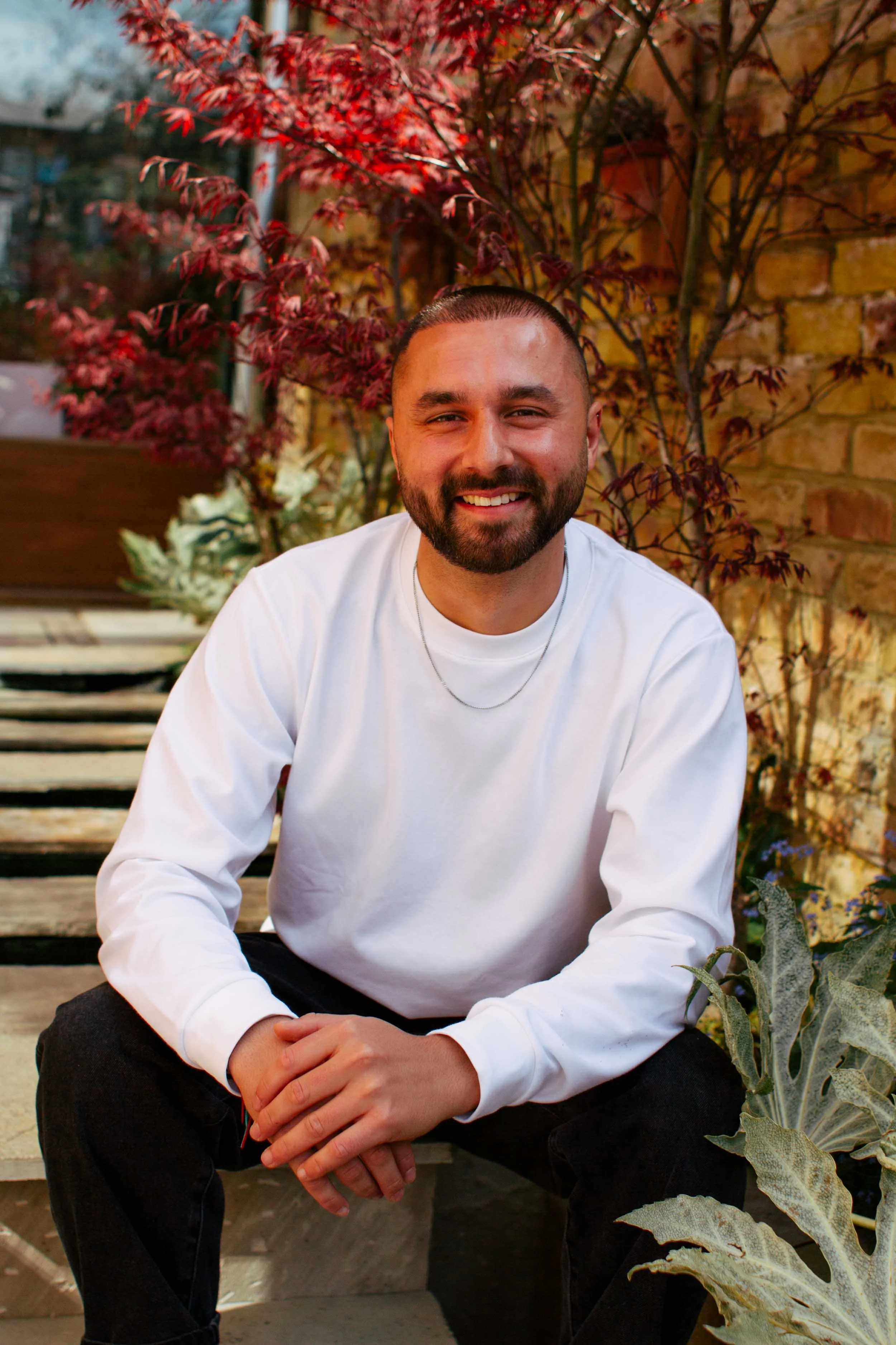 Outdoor portrait of mindfulness therapist surrounded by greenery, reflecting calm and grounded energy.