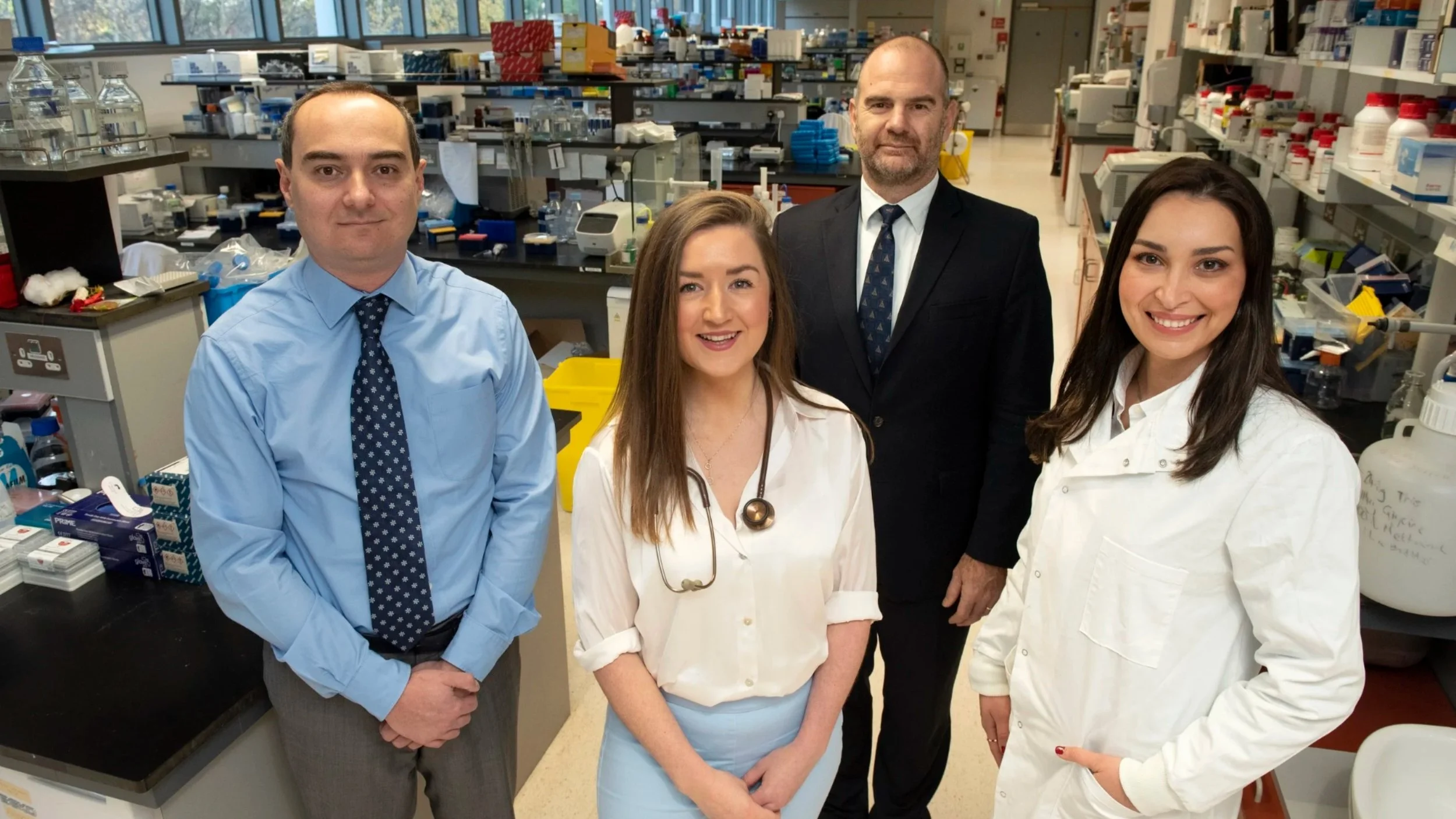 Doctor-led medical research team standing in a modern biomedical laboratory, representing clinically supervised, patient-first healthcare and medical expertise