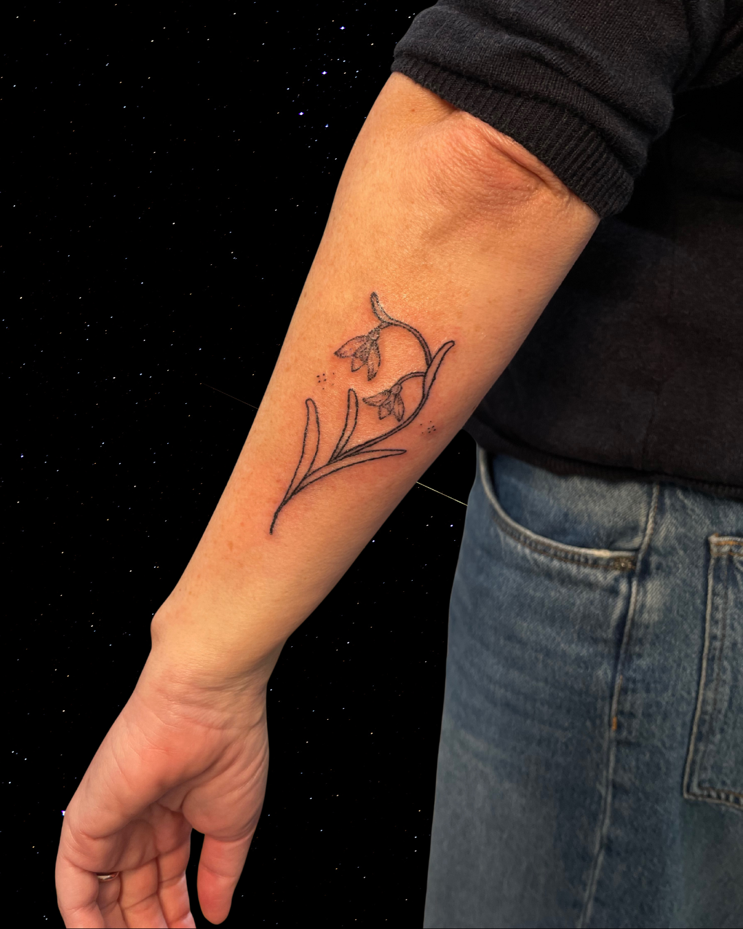 Hand Poked Tattoo of a Snowdrop Flower on a forearm