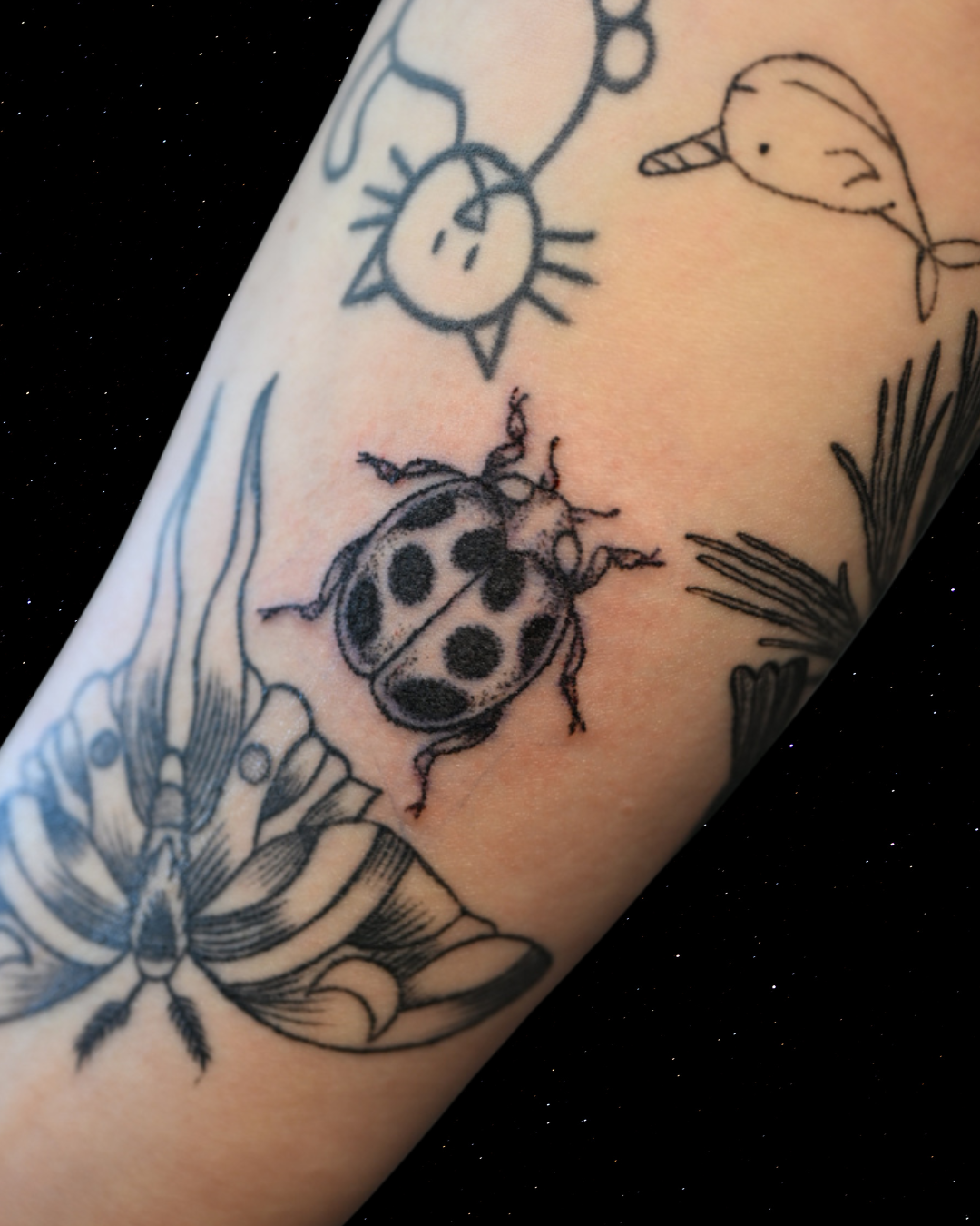 Hand Poked Tattoo of a Lady Bud on a forearm 