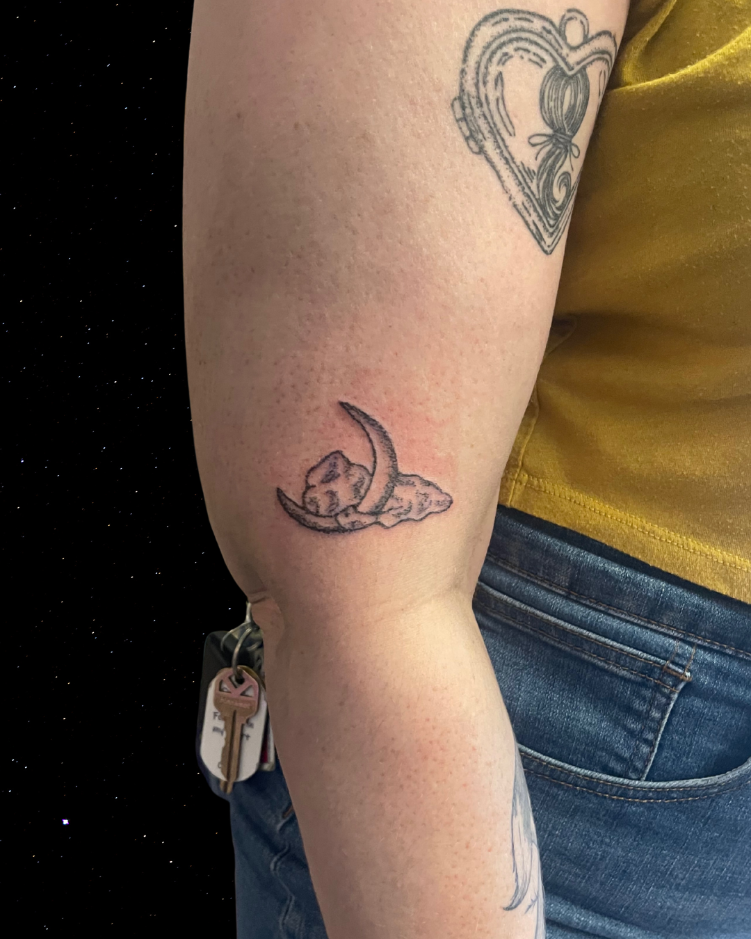 Hand Poked Tattoo of a crescent moon on their forearm