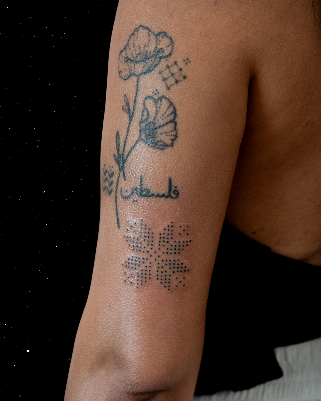 Hand Poked Tattoo of the word 'Palestine' written in Arabic, and a stylized textile pattern