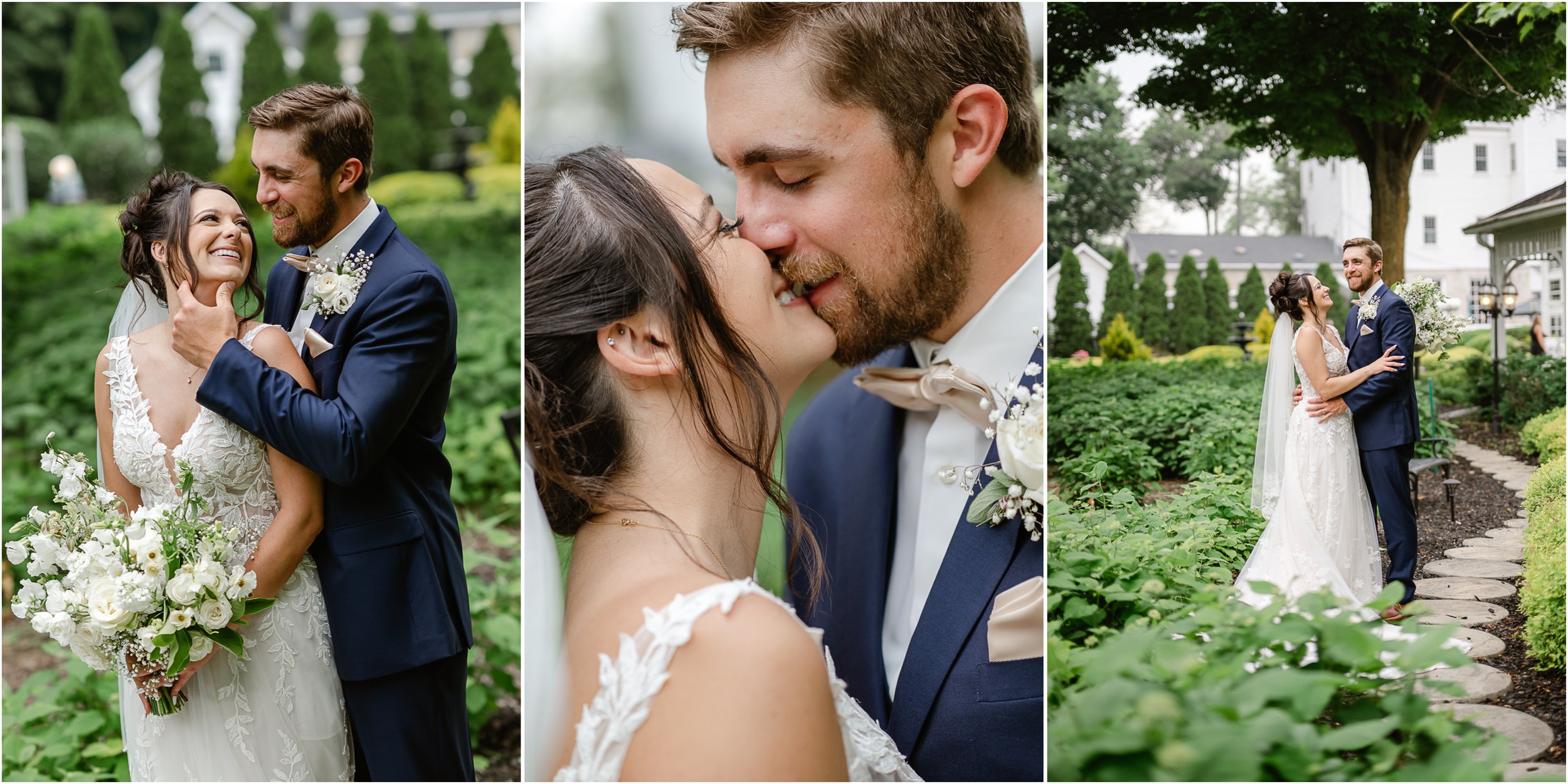 A wedding couple embraces in a garden. The bride wears a lace wedding dress and holds a bouquet of white flowers. The groom wears a navy suit with a beige bow tie. They share a close intimate moment, with the bride smiling and the groom gently holdin