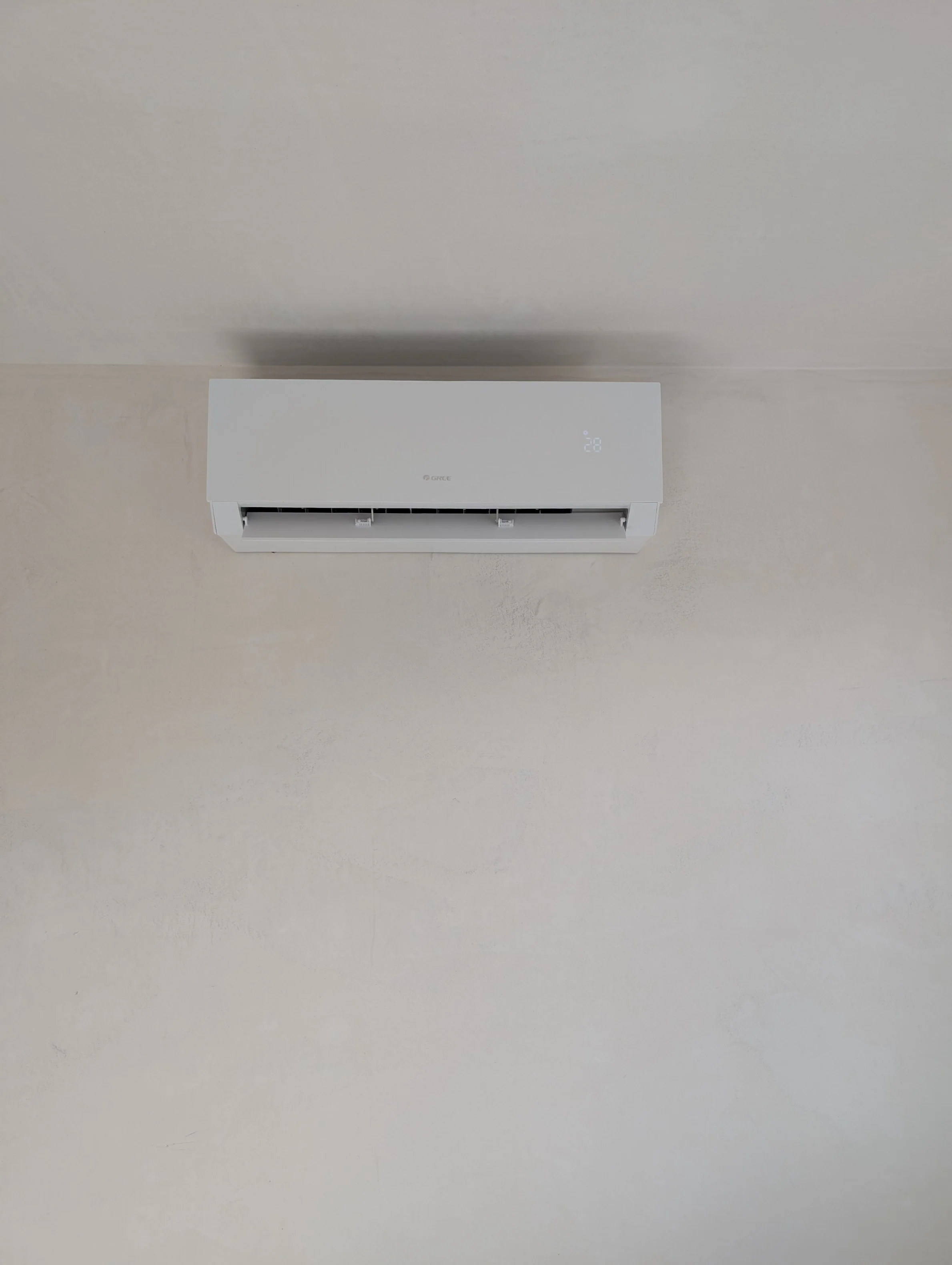 Wit airconditioner unit op een plafond.