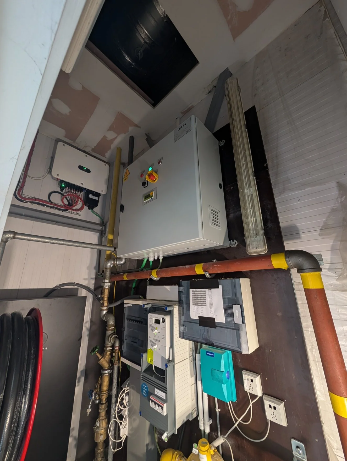 Elektriciteitskasten, leidingen en meters in een technische installatie.