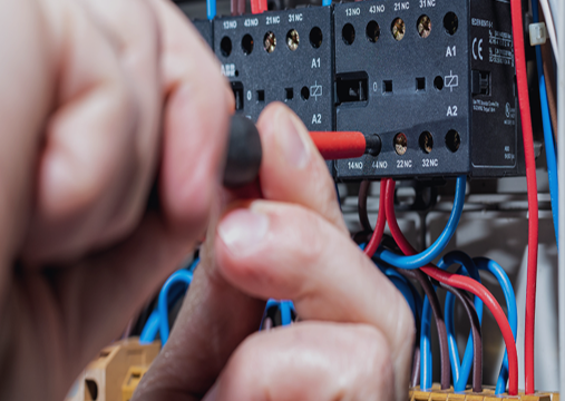 Persoon die draden aansluit op een elektrisch schakelkast of relais}