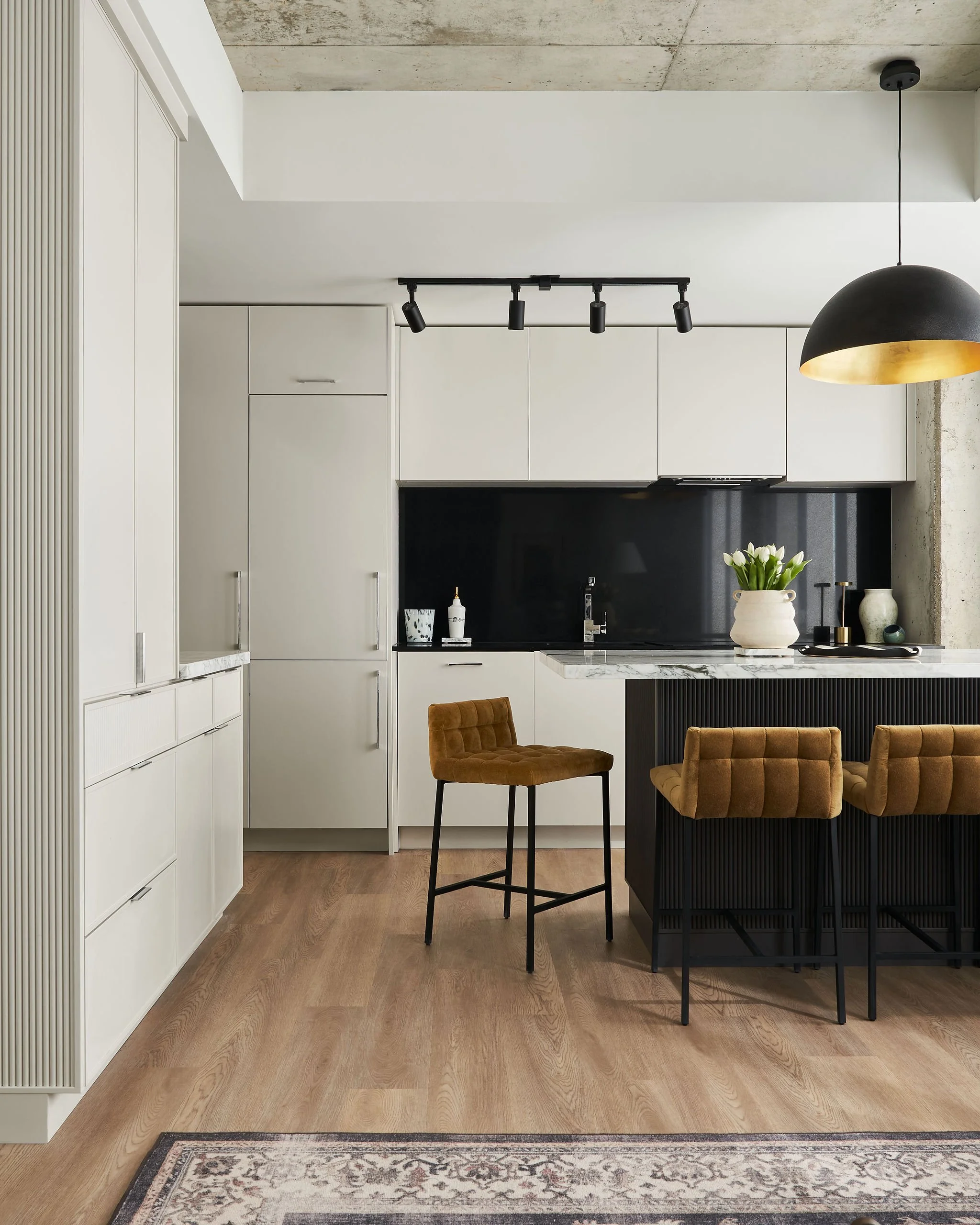 Custom black island with reeded details offset against the off-white perimeter cabinetry