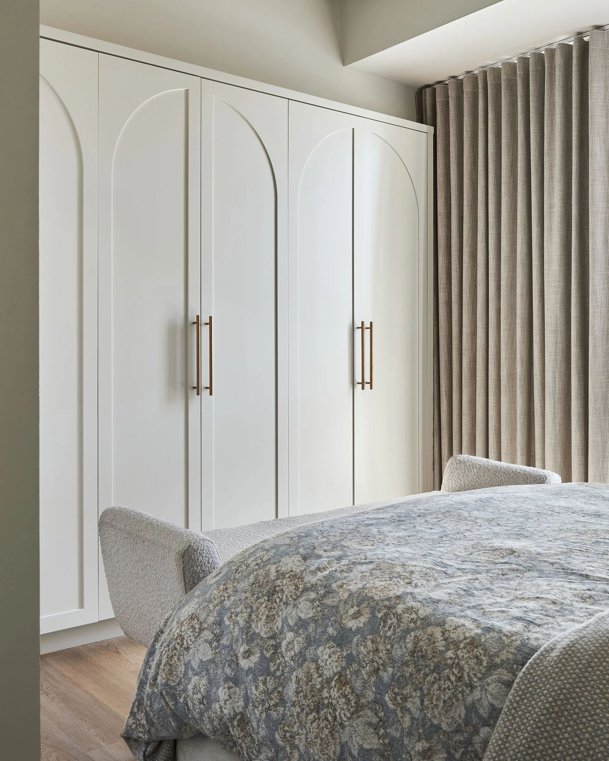 Custom closets provide functional storage in this condo bedroom