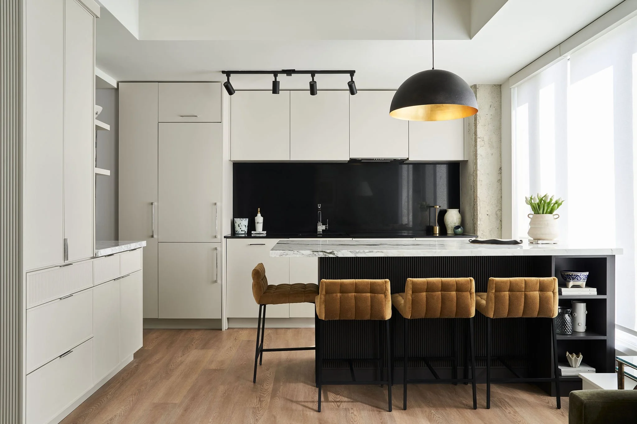 Custom black island with reeded details offset against the off-white perimeter cabinetry