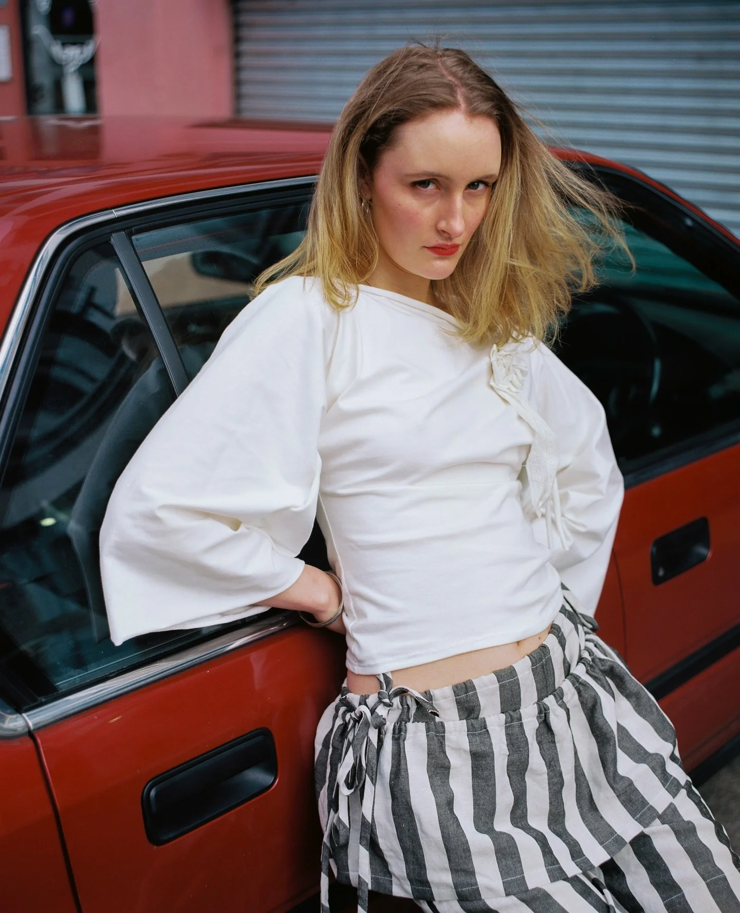 Rosa in the Rosette top in white, against Max's very cool car in red 

Photo by @maxballoch