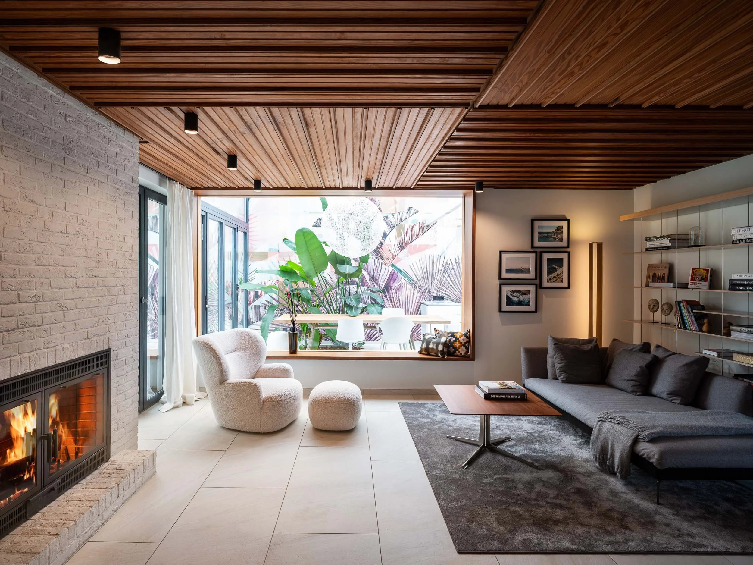 Innenraum eines Architekturprojekts mit Holzdecke, Kamin und Tageslicht