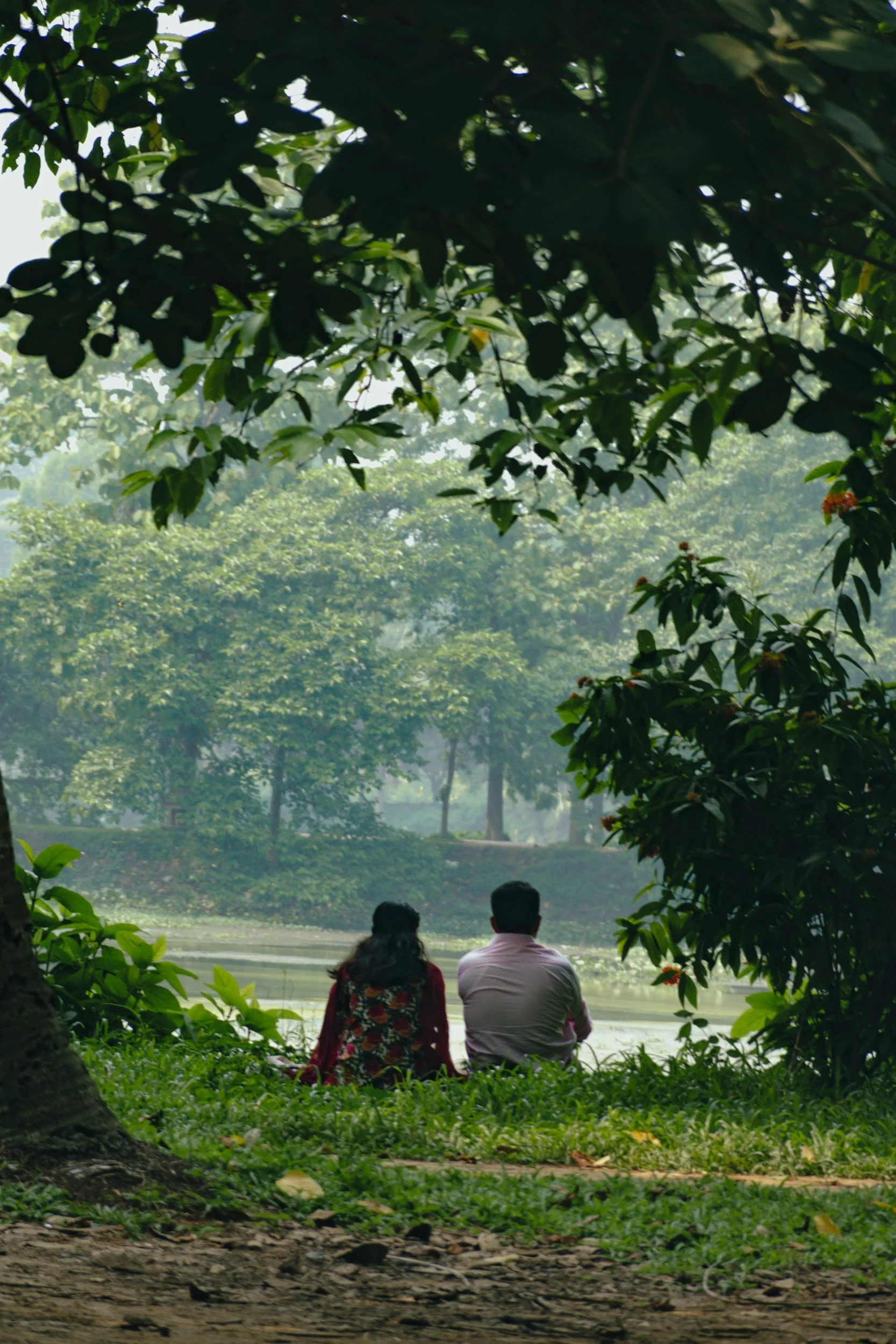 couple sitting on bank of river