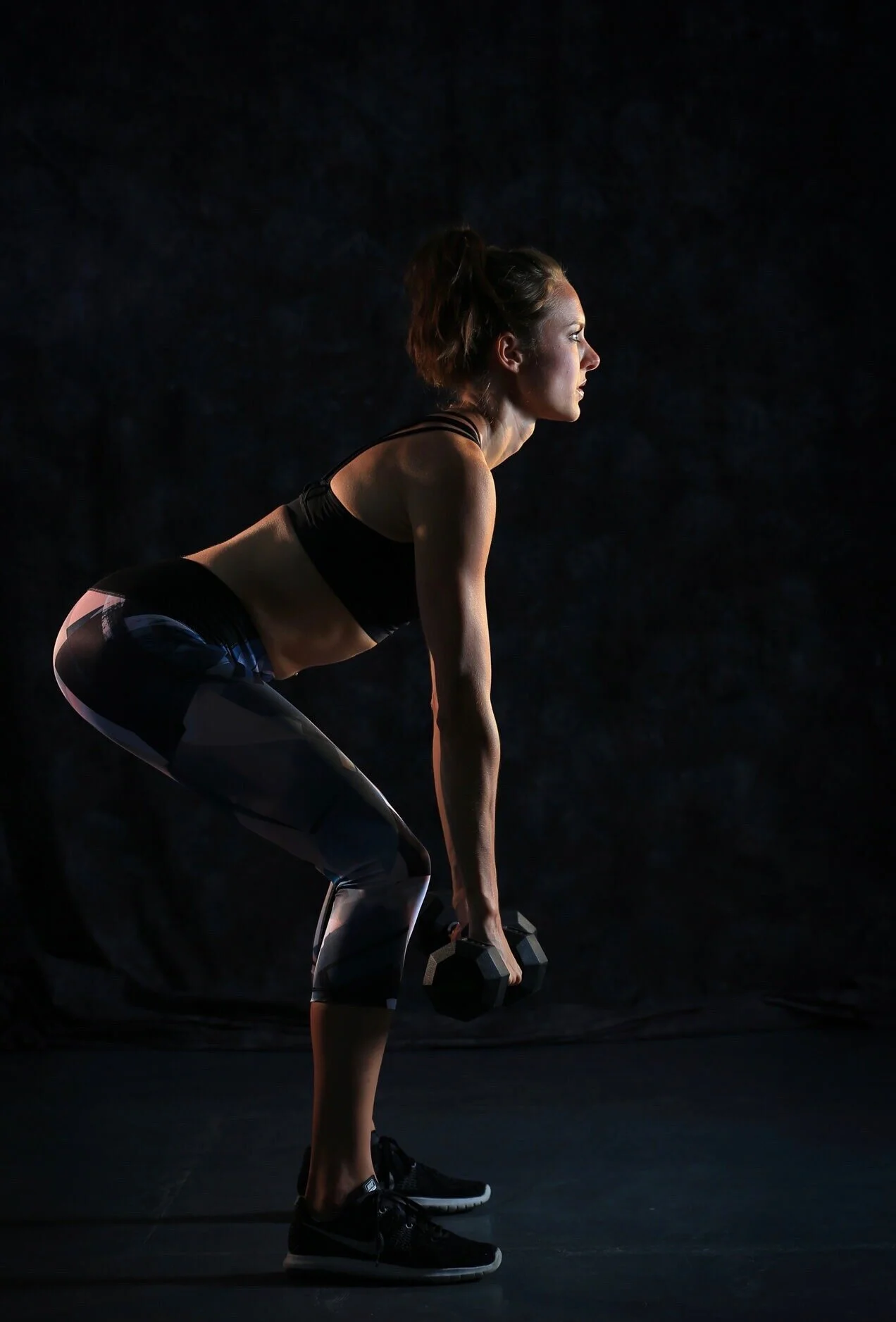 fitness photo of woman and dumbbells with edgy lighting