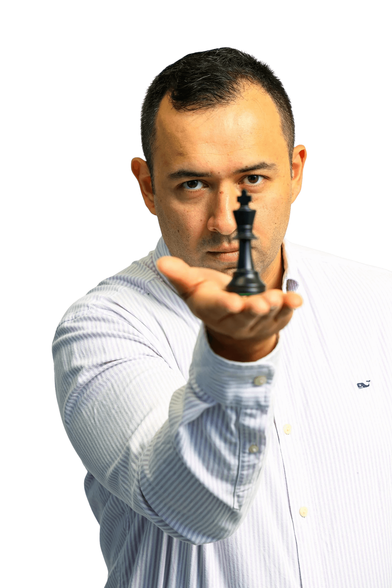 Man in a striped shirt holding a chess king piece towards the camera with a black background.