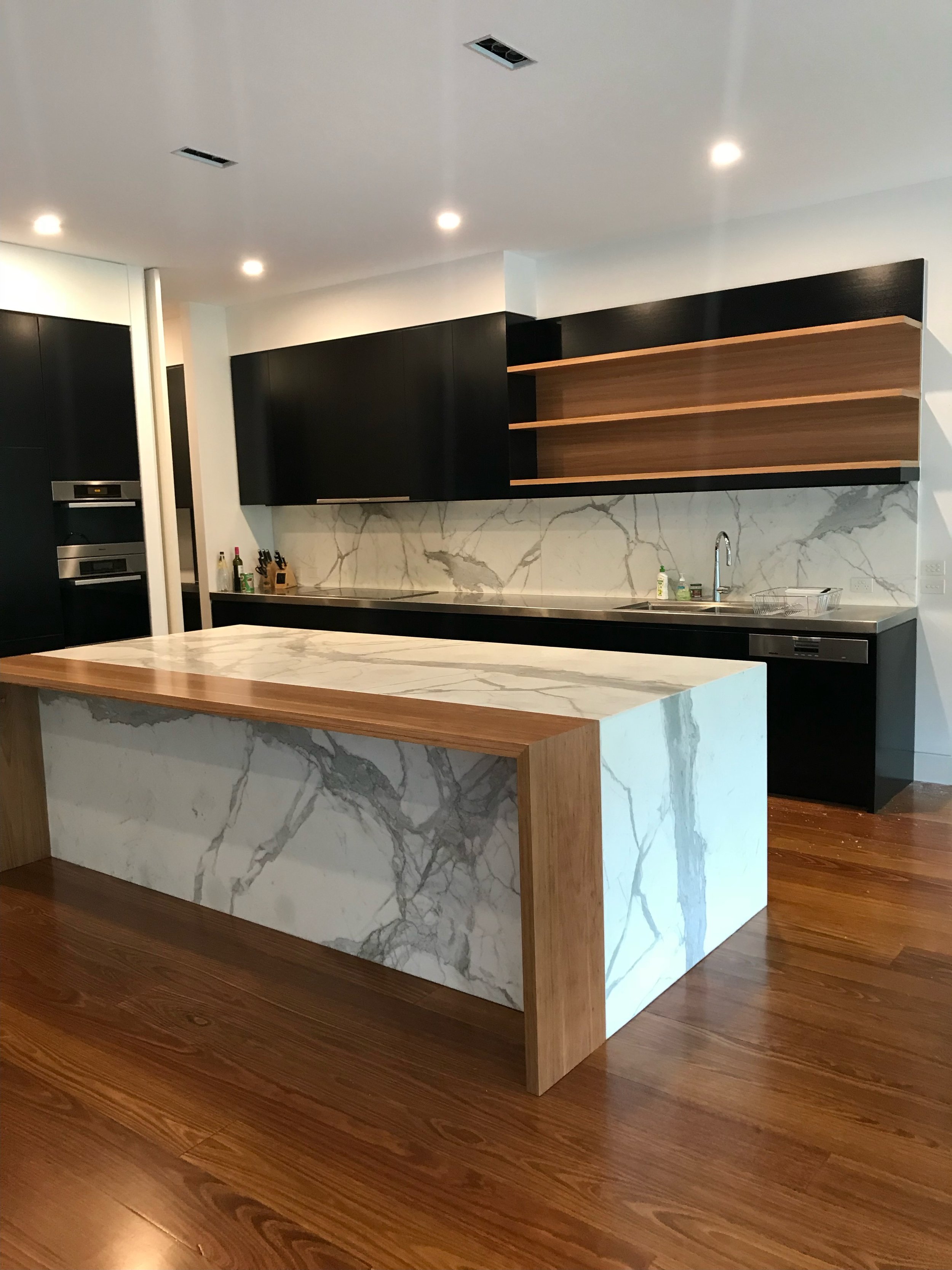 Kitchen black cabinets white marble with wood two tone.jpg