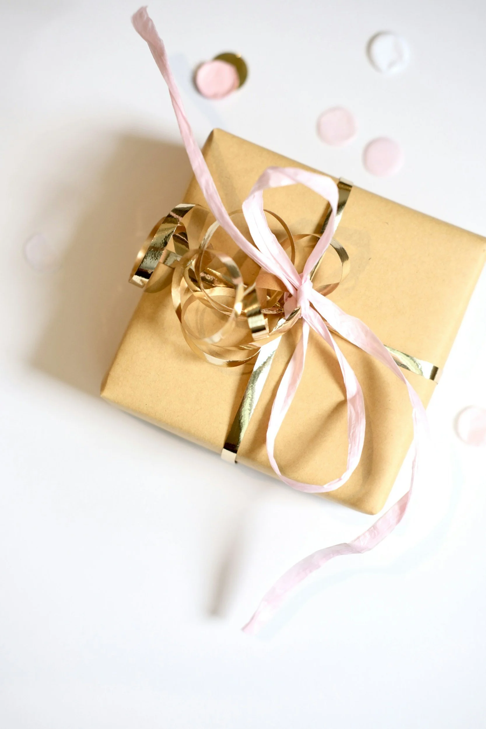 a wrapped present with gold and pink ribbon